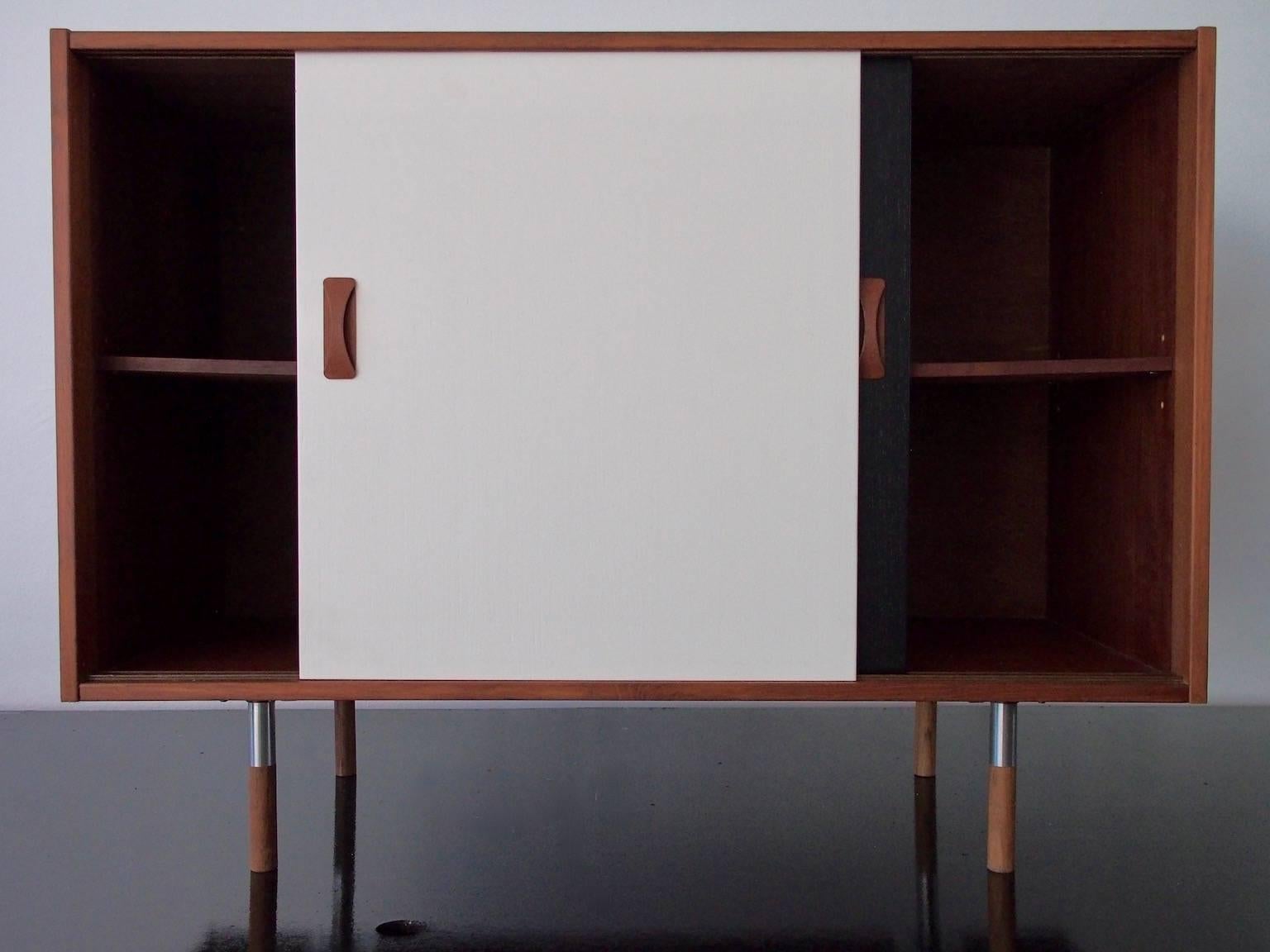 Clausen & Søn sideboard veneered with teak, front with lacquered black and white sliding doors. Later mounted unoriginal brushed steel legs with shoes of teak, circa 1960s.