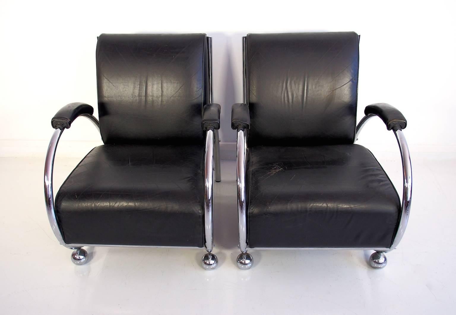 Pair of armchairs chrome and black leather armchairs, circa 1950s, Germany. Chrome-plated base, rounded tubular steel construction. Front padded on two ball feet and rear flared legs. Seat, back and armrests covered in black leather.