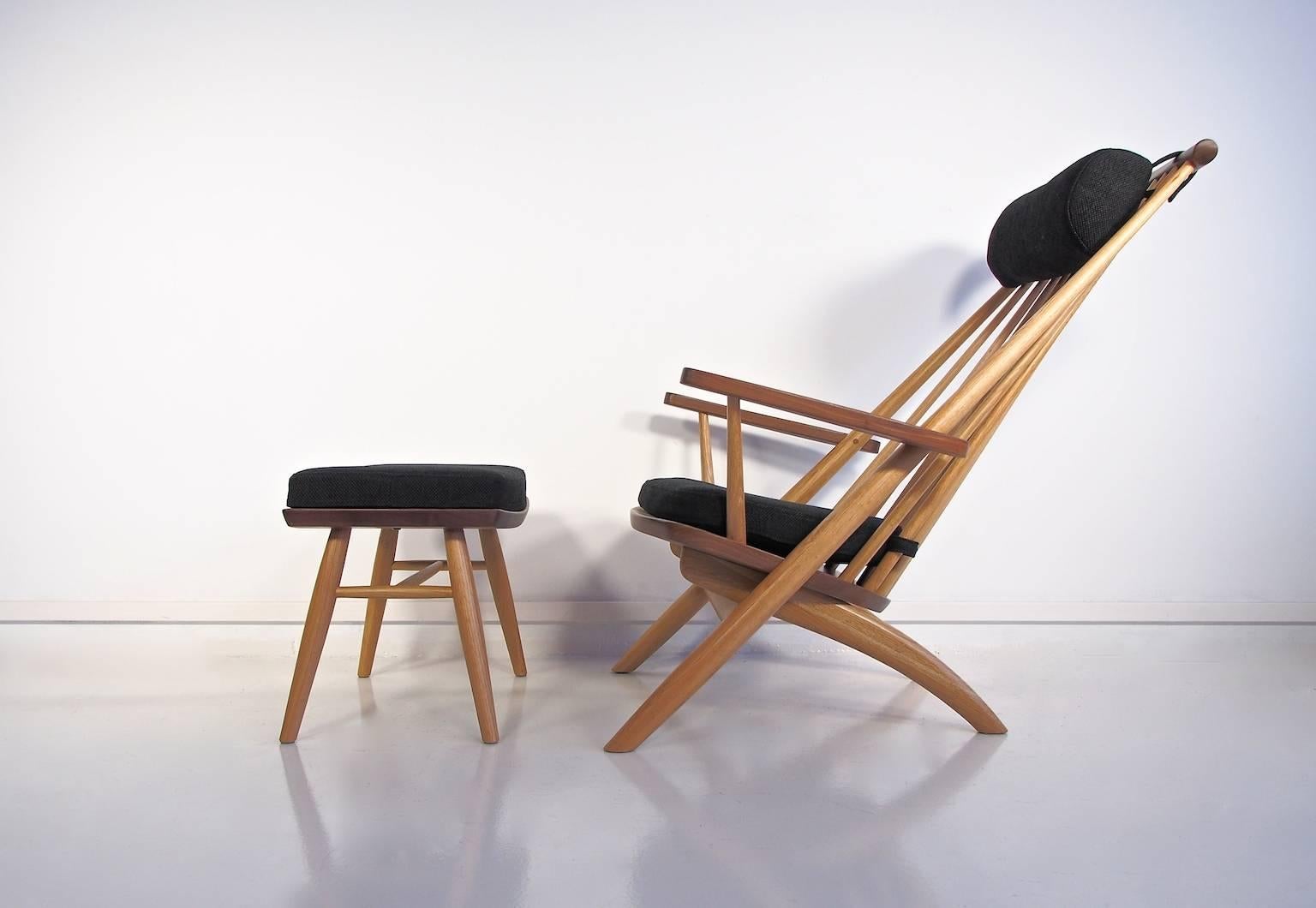 Easy chair and matching foot stool designed by Tateishi Shoiji in the 1950s and produced in Finland in the 2000s. The detachable seat cushion and neck support is upholstered in dark grey fabric. The chair is made of oak with walnut seat, armrests