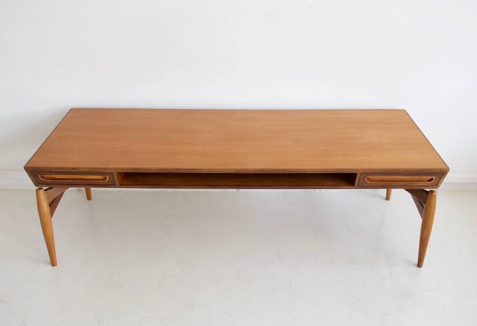 Johannes Andersen teak coffee table for Trensum; tabletop built on a sculpted stand, made of teak, mahogany and walnut woods and produced by Trensum during the 1960s. Two drawers with carved pulls that can be opened from both sides of the table and