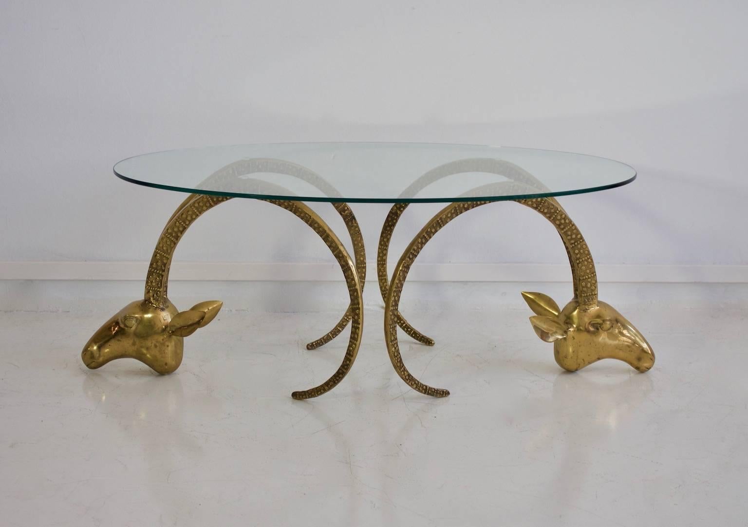 Ram's head or ibex coffee table in the style of Alain Chervet. Frame in the form of two ibex heads made of brass, with overlapping oval glass plate.