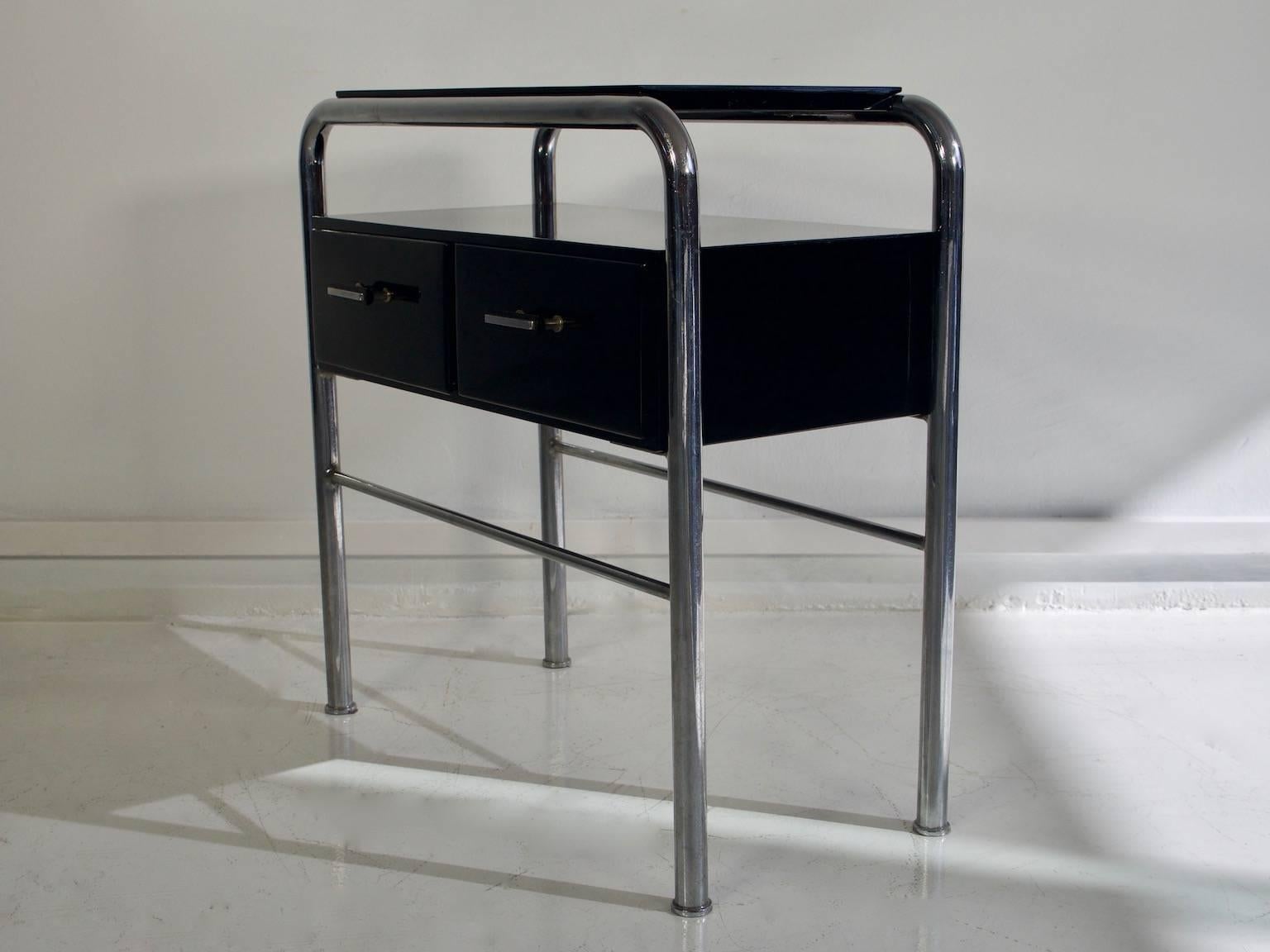Small Bauhaus side table with pull out drawers in black lacquered wood and steel tube structure, 1930s. The wood has been restored and the tubes are in original vintage condition.