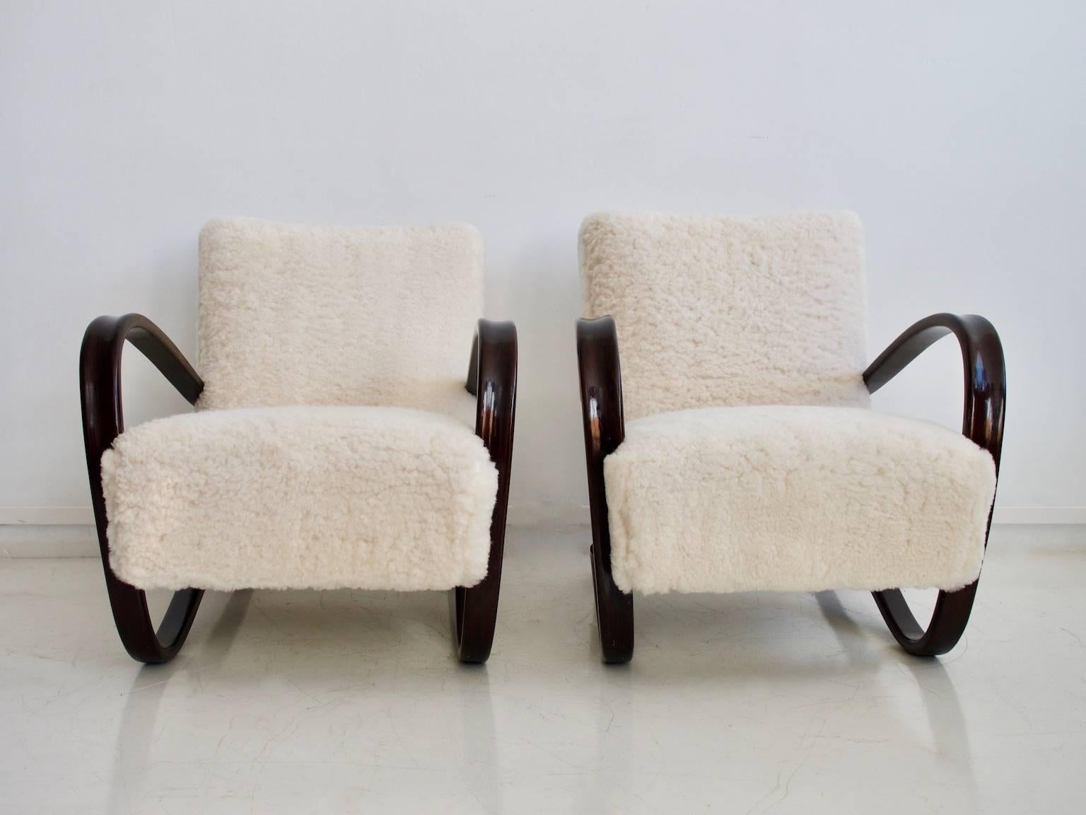 Pair of armchairs, model Kreslo H269, was designed by Jindrich Halabala (1903-1978), chief designer of the furniture factory Spojené UP Závody in Brno, circa 1930. These comfortable lounge chairs feature a varnished wood frame, bent into a U-shape,