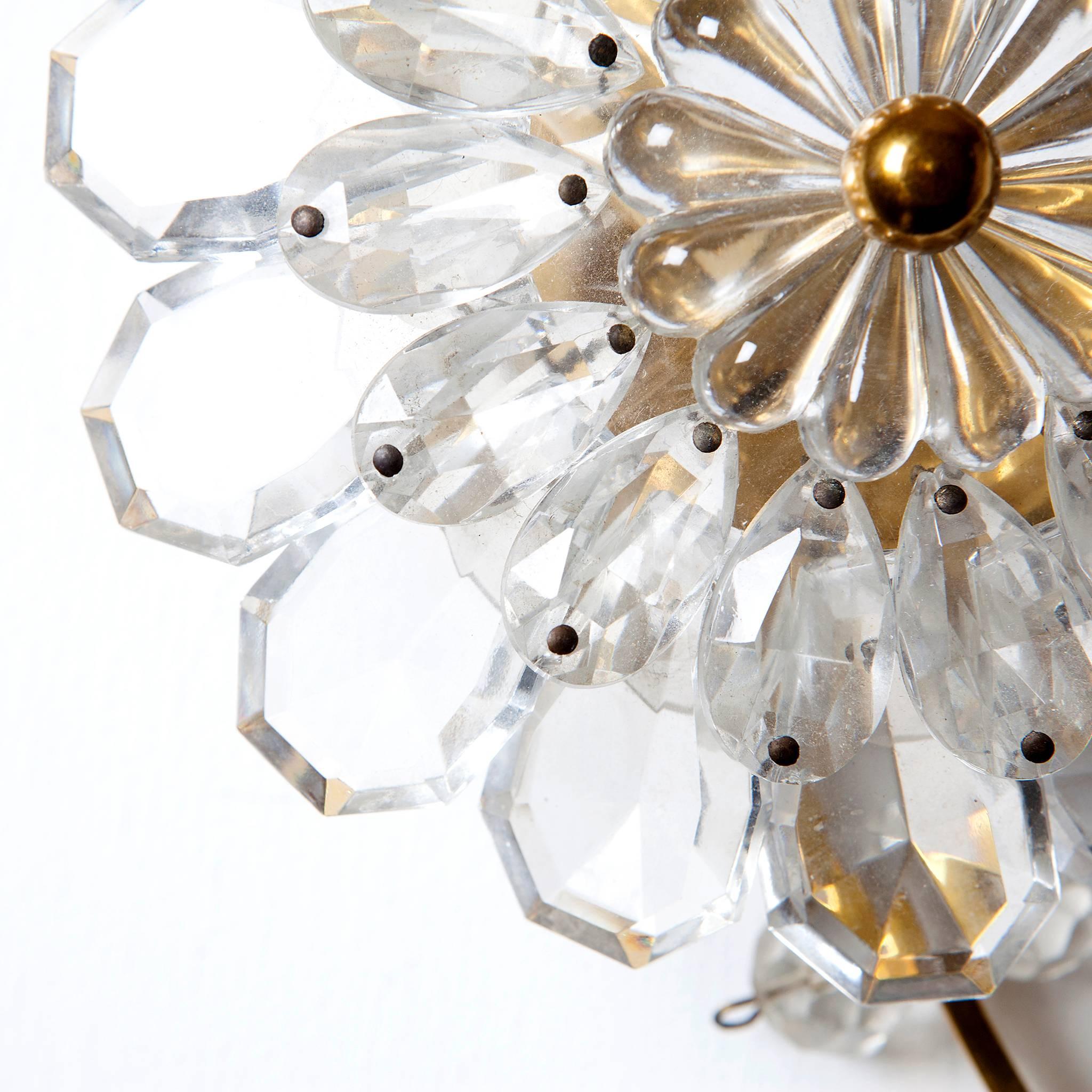 A gorgeous flower shaped sconce from 1950s in style of Lobmeyr. Gold-plated brass and crystal glass. 
