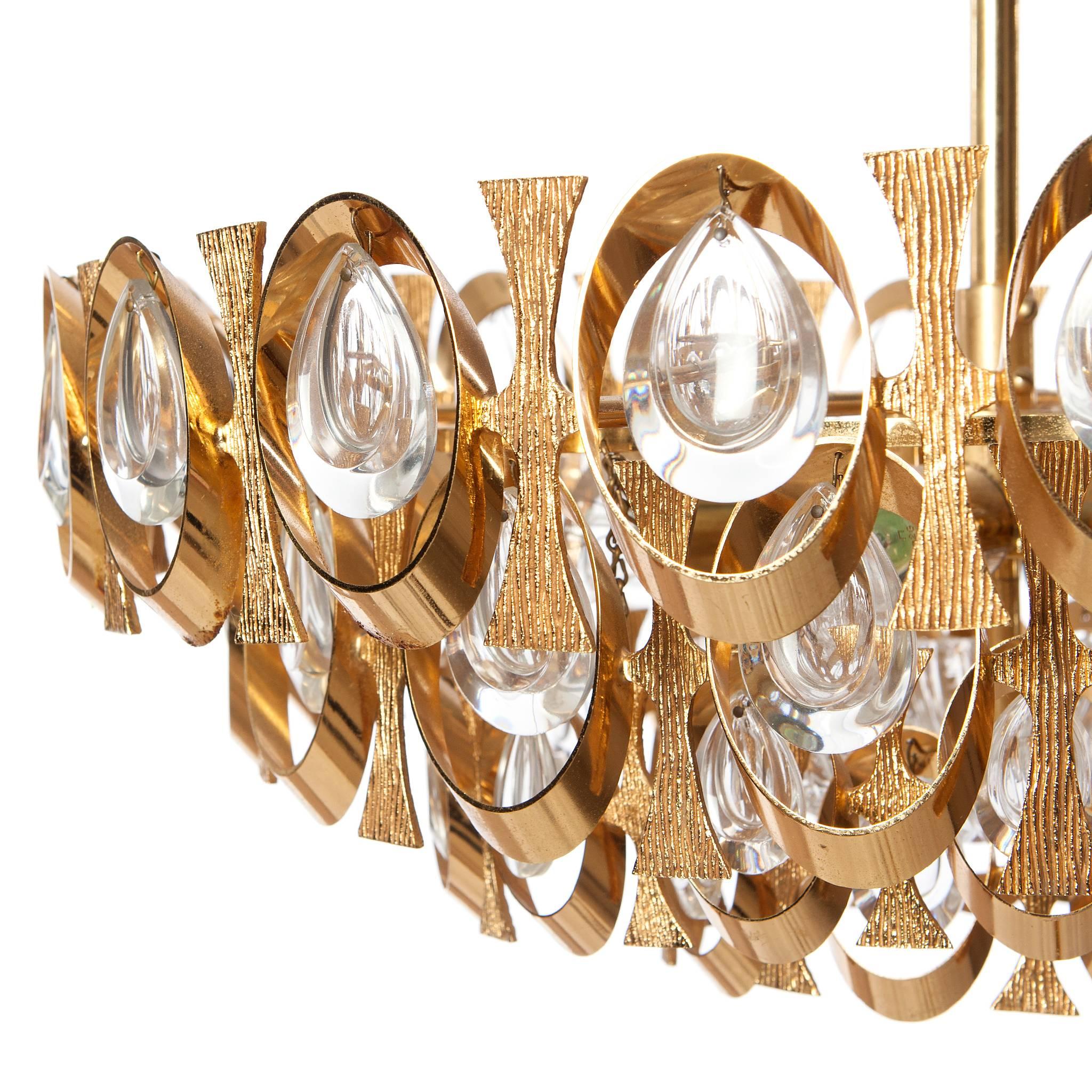Unique eight-light chandelier with gilt brass beautifully shaped rings and plates. Its truly amazing with all it's crystal prisms excellent condition. By Gaetano Sciolari for Palwa.
Please note we have several chandelier in similar style and sizes.