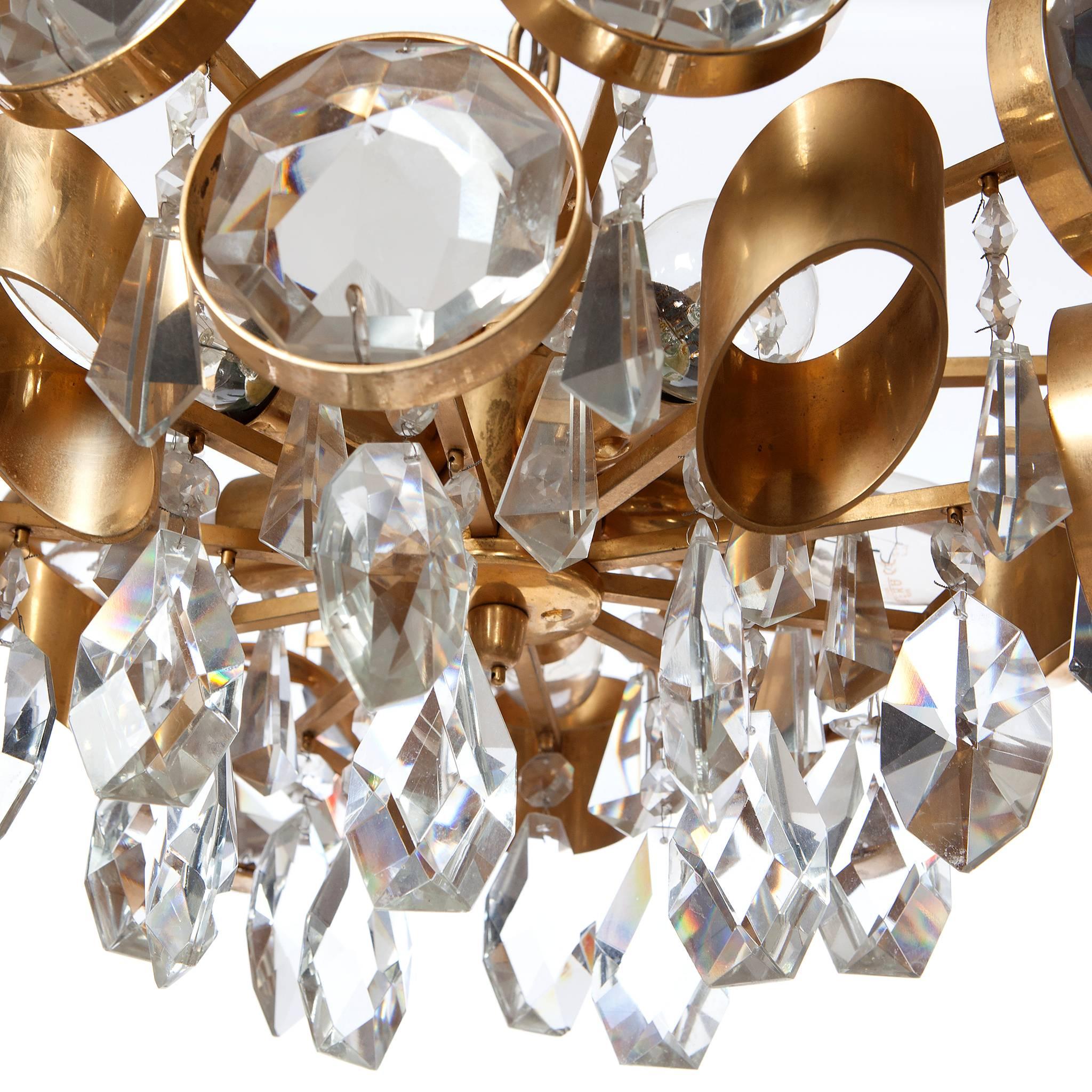 Elegant 1960s chandelier with with five E14 sockets that shine through multiple diamond-cut crystal glass charms and golden gilded brass body and rings. 
Please note that we have more chandeliers and scones in similar style and in different shapes