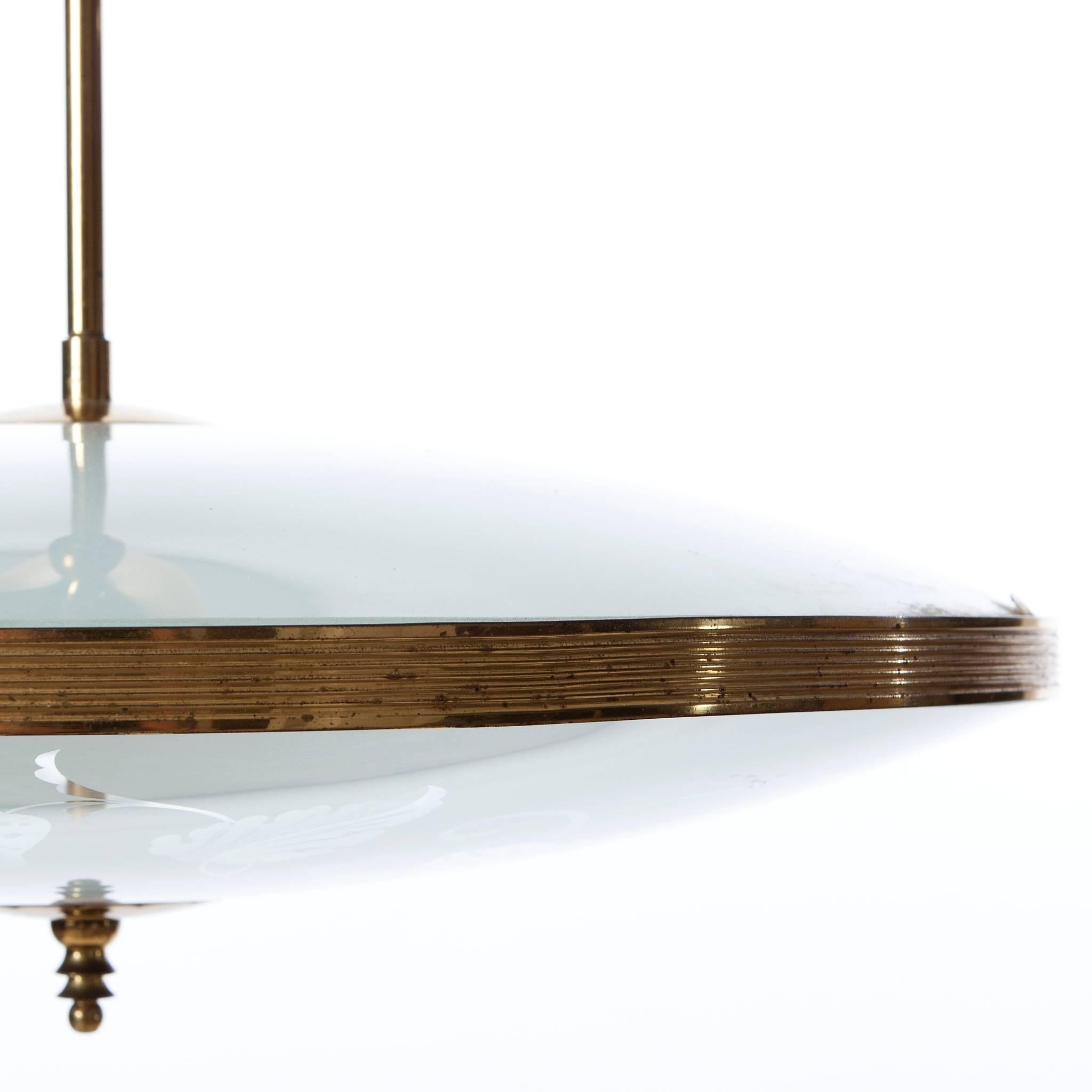 This elegant piece consisting of a brass frame and 2 unique frosted and satin glass reflector/saucers. 
The lower round curved glass reflector with floral motifs mounts below a round satin glass reflector. Finished off with a brass decorative ring.