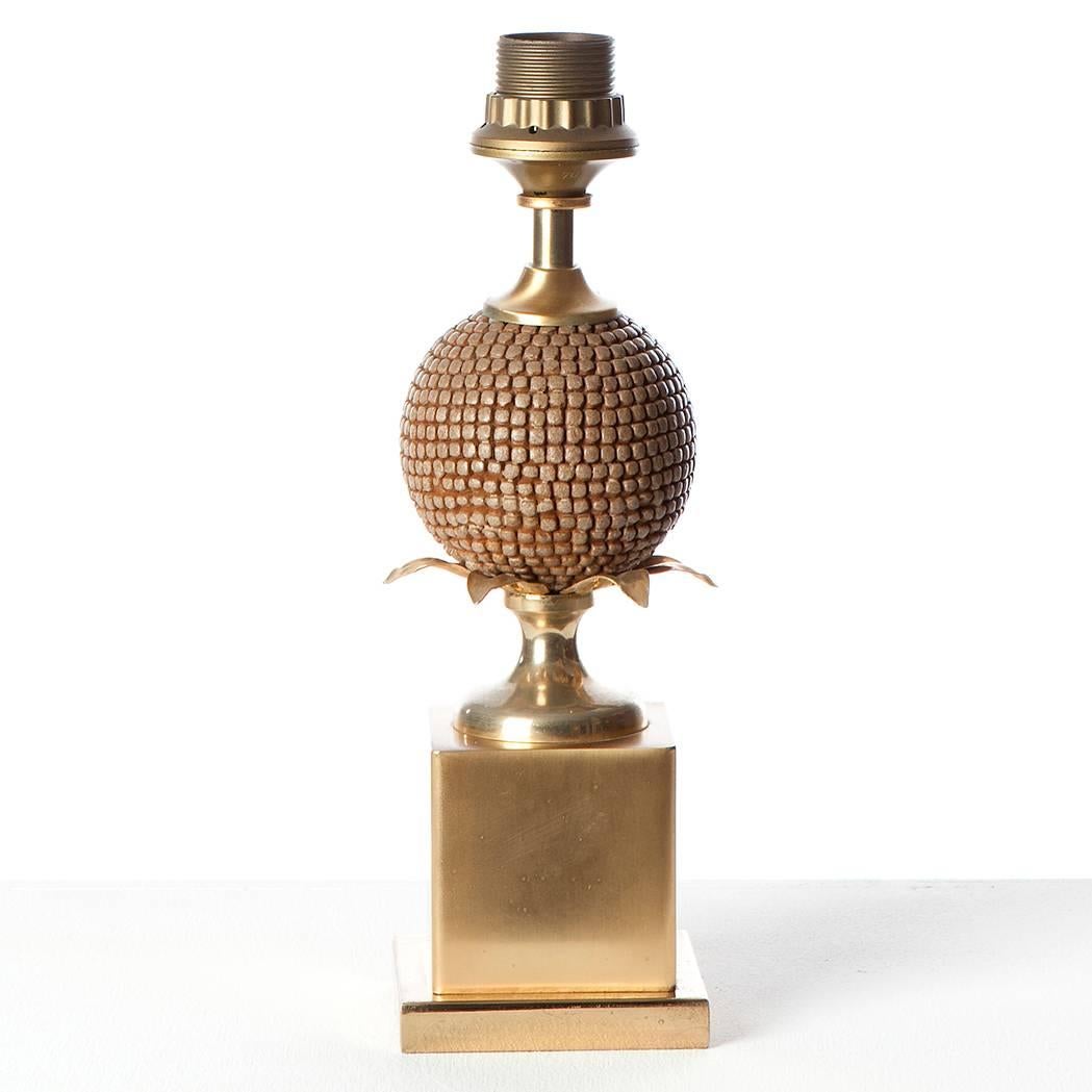 Elegante lampe de table française avec une forme inhabituelle de ce qui semble être une boule en forme de graine. Il est posé sur des feuilles de bois et est muni d'un pied en laiton massif.
La lampe est livrée sans abat-jour.