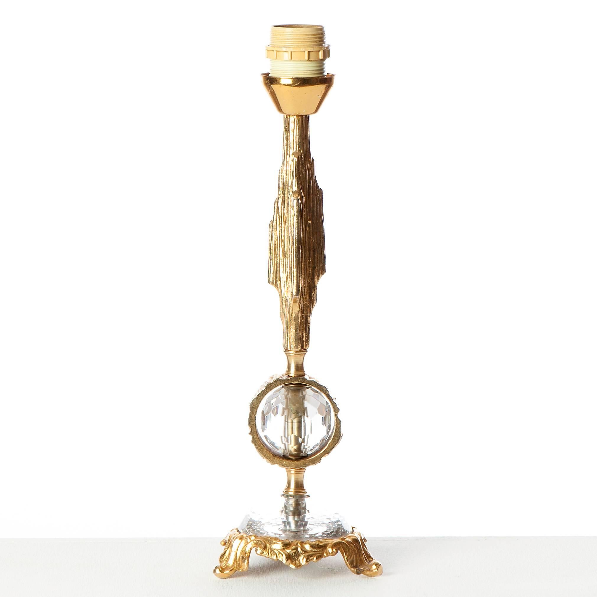 Very elegant brass table lamp with cut-glass ball in the centre. The ball is surrounded by a brass ring. Also the foot is combined with glass and brass. 
The lamp comes without shade. 

For more information please do not hesitate to contact us!