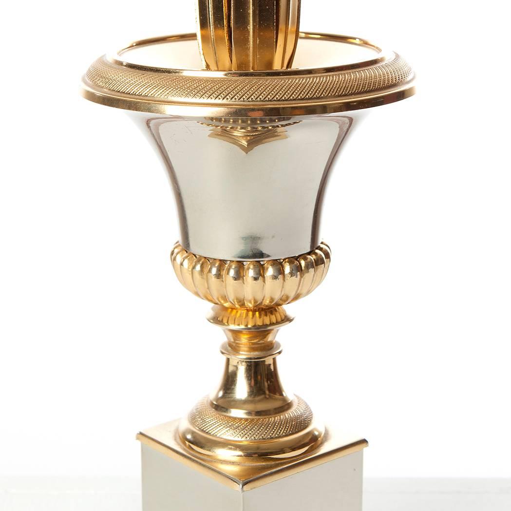 Elegant two-tone brass & steel French table lamps with pineapple out-scrolled leaves coming from an urn, ( the urn being a symbol of well being) 

We have 5 medium size lamps that hold two bulbs. (4 x silver mirror foot&urn, 1x matt gold foot&urn 1