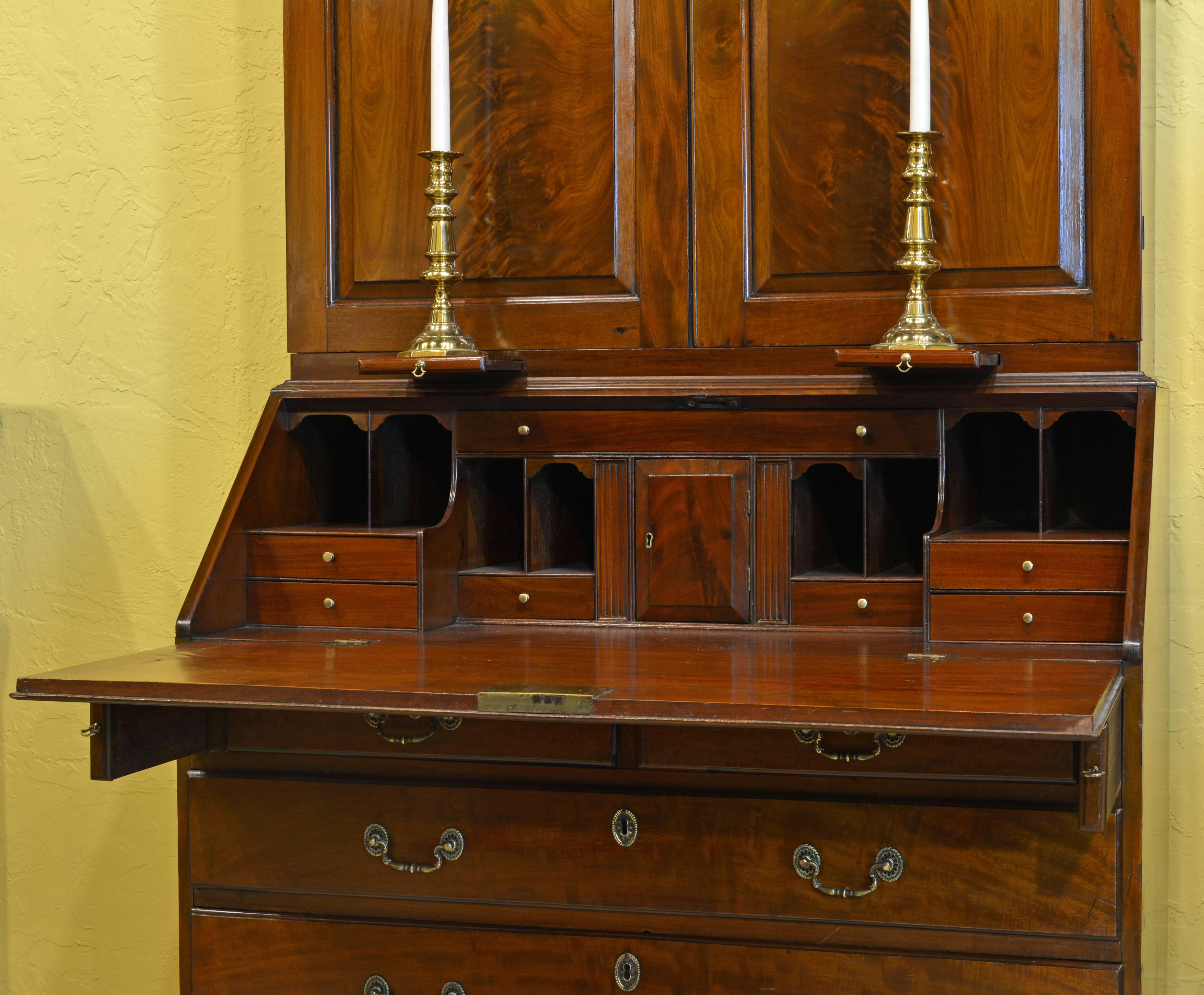 Of classical proportions and with the warm glow of the flamed mahogany this secretary bookcase consists of two parts. The upper part features a dentil molded cornice above two paneled doors, enclosing a shelved interior under which you find two