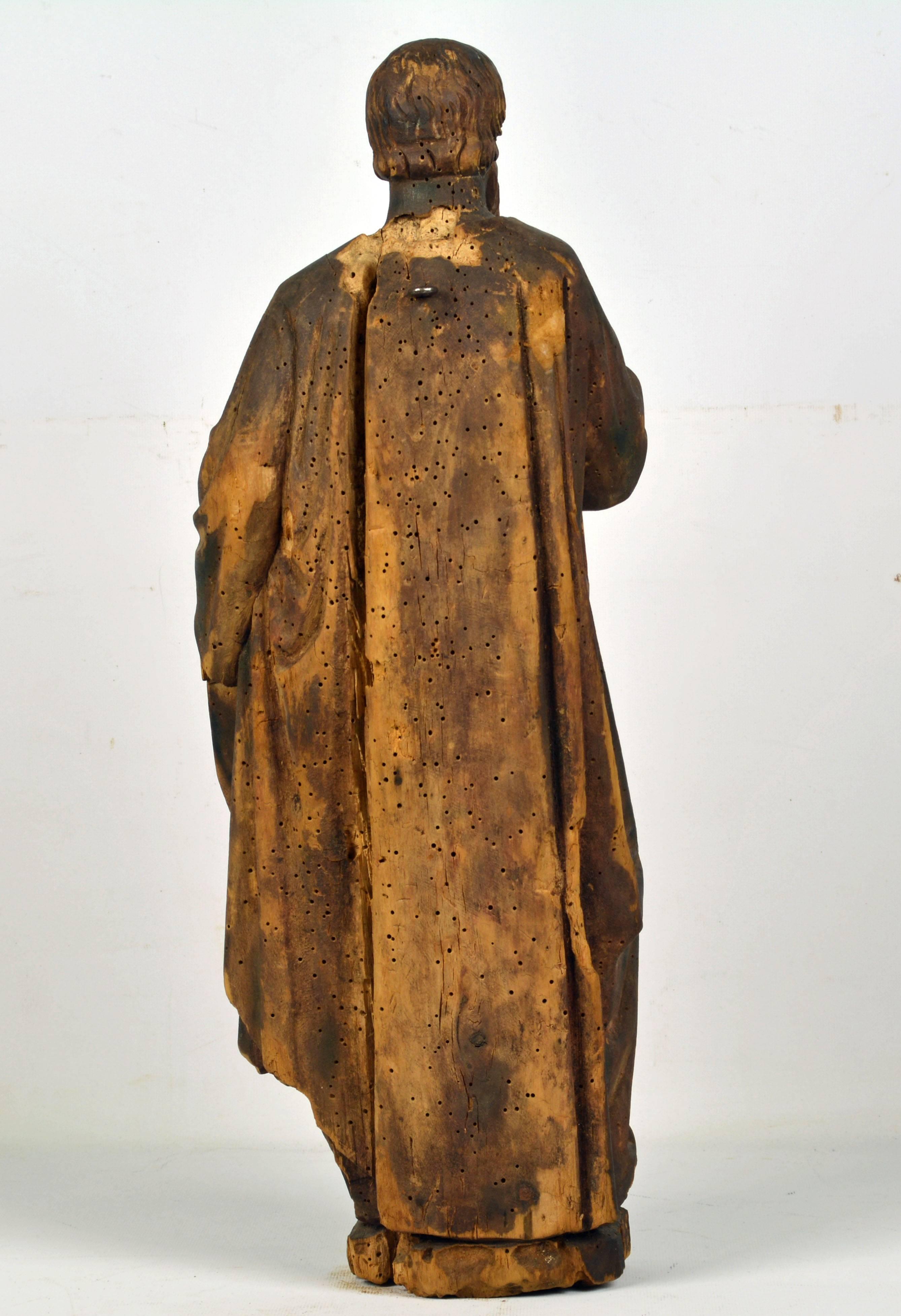 Standing 21 inches tall this 18th century or late 17th century Italian school carved statue represents a religious figure standing right hand to the chest wearing richly draped garments. It is well carved and capturing a subtle dignified facial