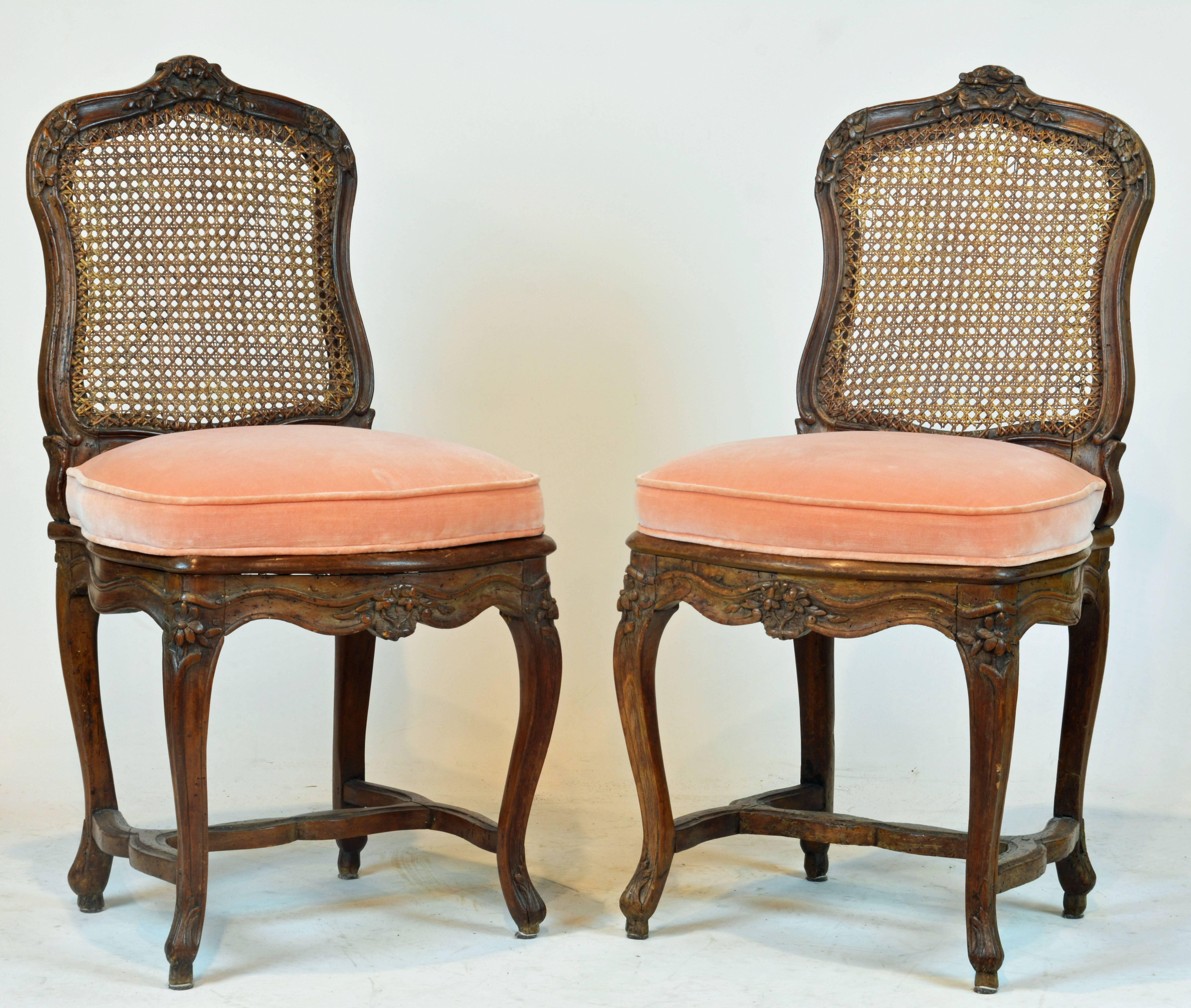 Retaining a lovely color these carved and caned walnut chairs date to the mid-18th century wearing their age gracefully. They come with newer removable custom-made upholstered seat cushions of good quality and condition.