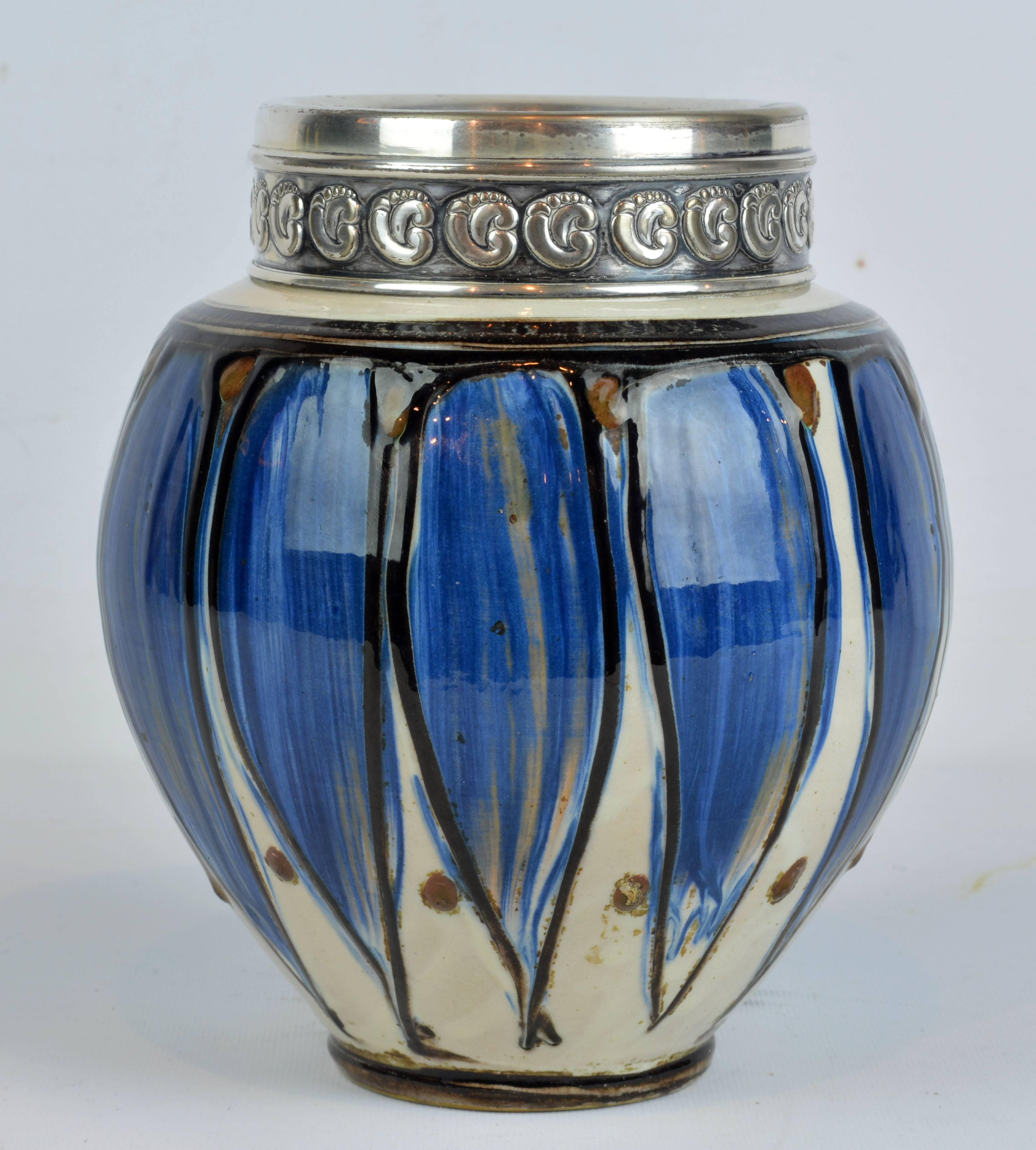 An important silver plate mounted ceramic vase by Thorvald Bindesbøll 1846-1908 for Herman A. Kahler pottery in Denmark. Dates to circa 1900-1910. The silver plate mounted neck with repousse ornaments in the Scandinavian arts and crafts style
