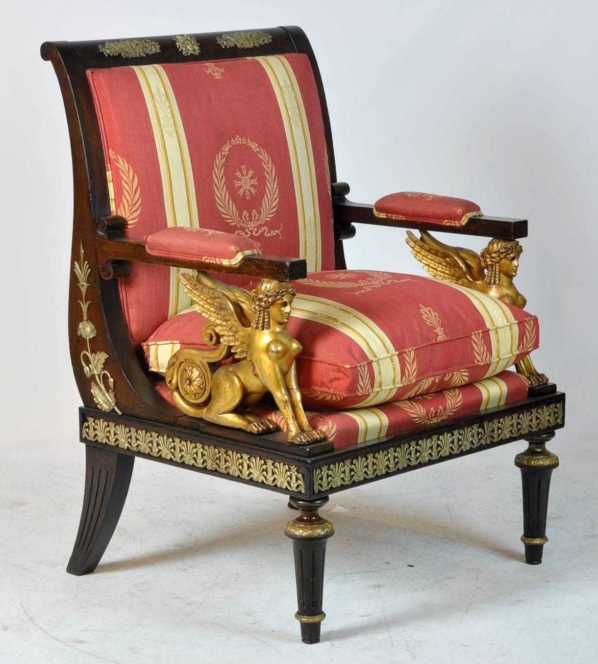 Pair of large French armchairs with gilt sphinx's on each arm. Empire revival period with bronze mounts around the chairs. Unusual form and sturdy.
