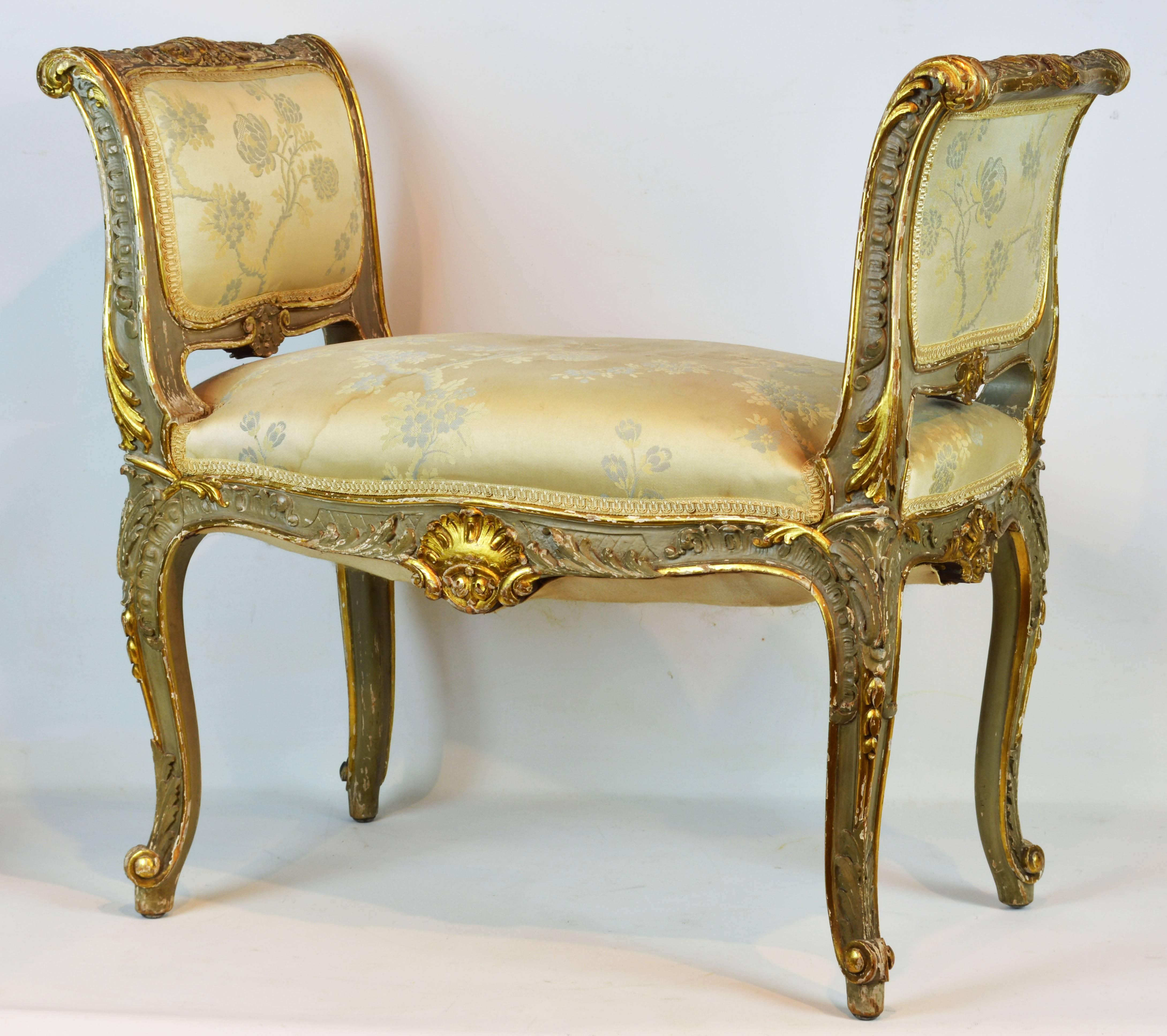 A charming bench with cabriole legs in the Rococo style richly carved with gilt leaf work and scrolls centering fine shell carvings on both sides.