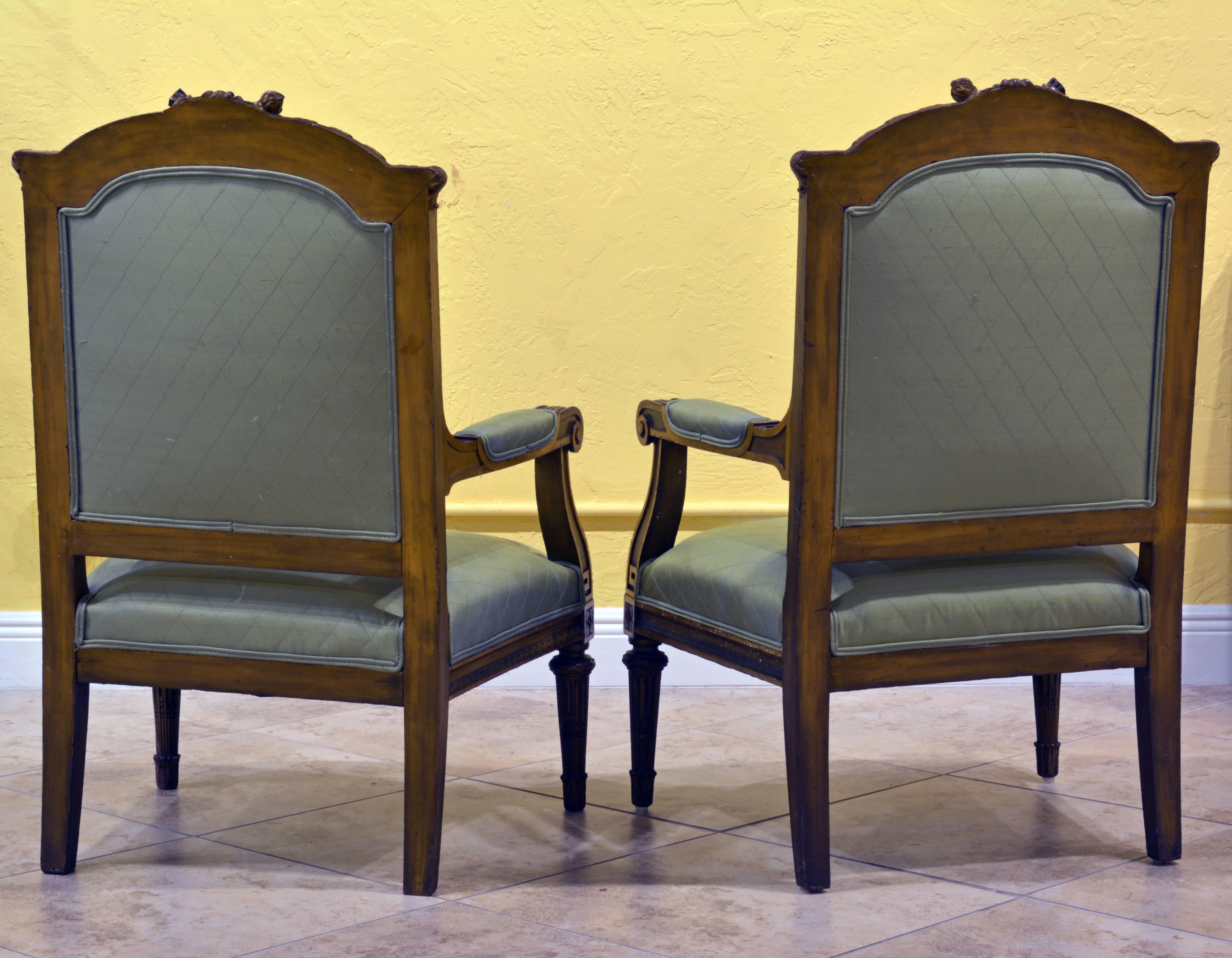 These elegant chairs feature rope carved back frames headed by the classical crossed torch and quiver motif, popular during the Louis XVI reign. The beautifully leaf carved armrests continues in round tapering and fluted front legs. The chairs are