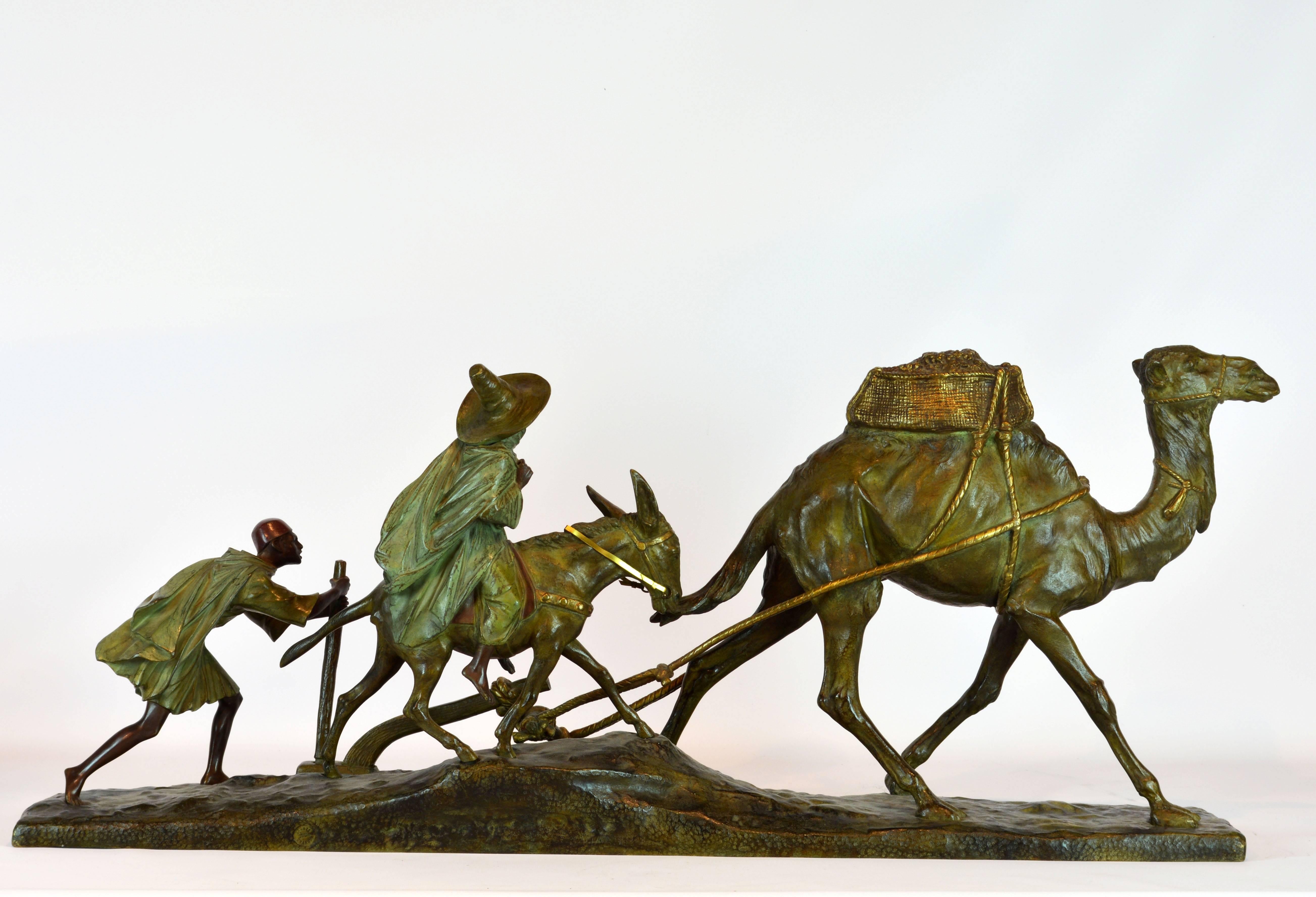 31.5 inches long and 13.5 inches tall this famour bronze group by Edouard Drouot features an Arabian Camel drawing a plough operated by a young boy and followed by a woman mounted on a mule. The signed sculpture is modeled with rich in detail and