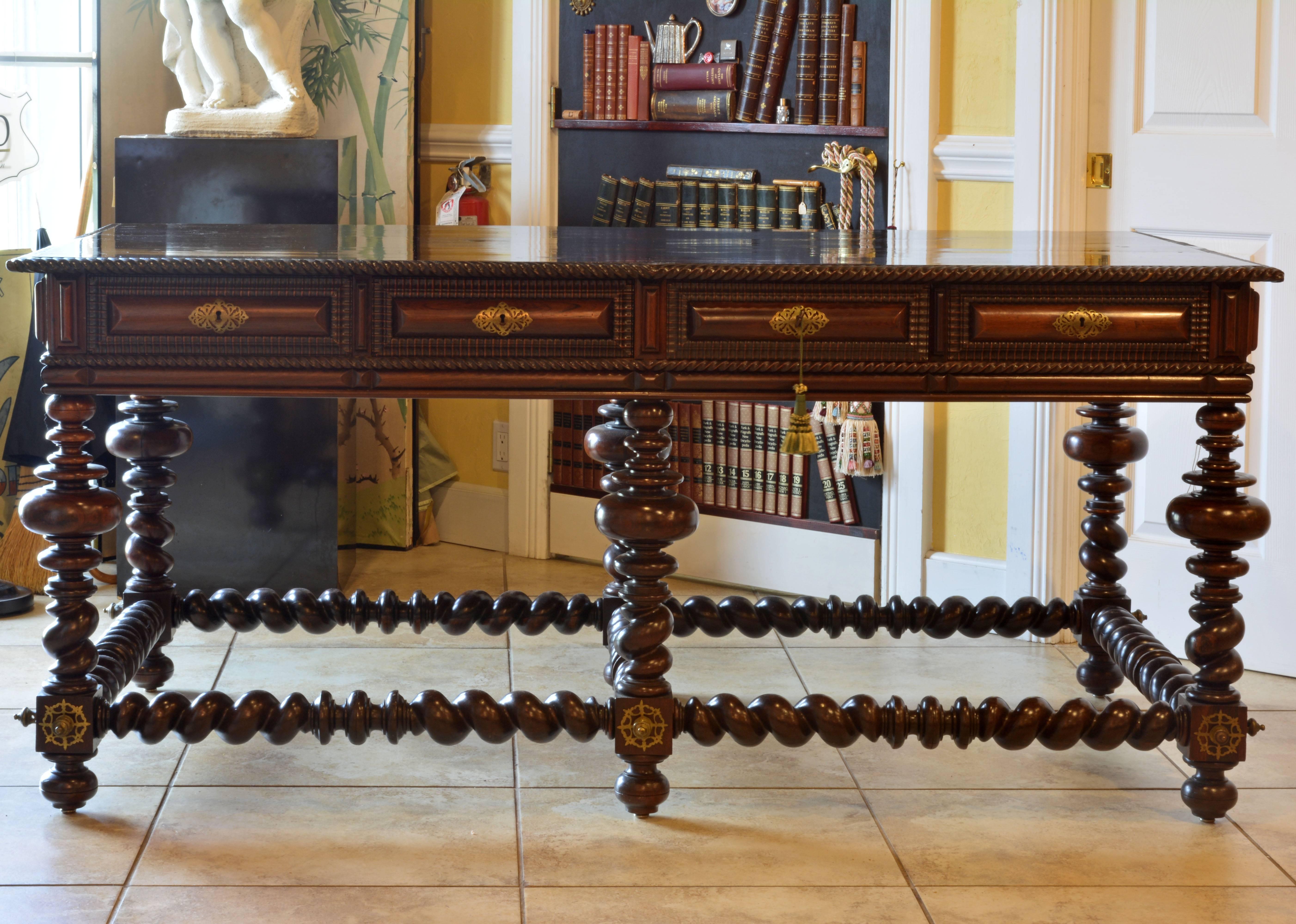 A magnificent and unusually large 'mesa butte' table featuring a polished top with spiral carved edge above eight carved frieze drawers, four on both long side a and two simulated drawers both short sides, supported by bulb, ring and spiral turned