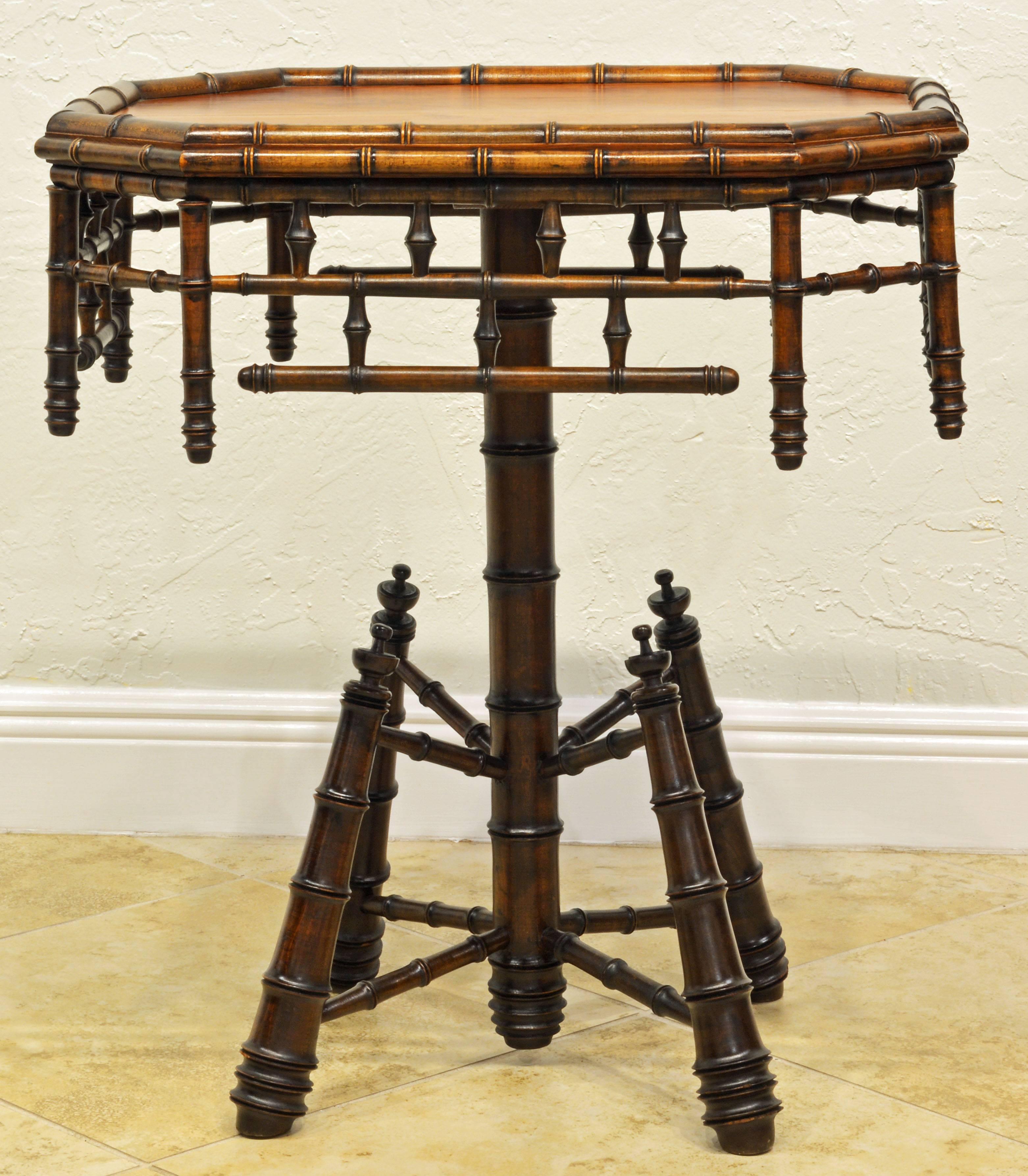 This interesting and unusual table features a polished faux bamboo edged pine top above a faux bamboo fretwork frieze resting on a single stem turned leg ending in an unusual construction of four conical turned legs.