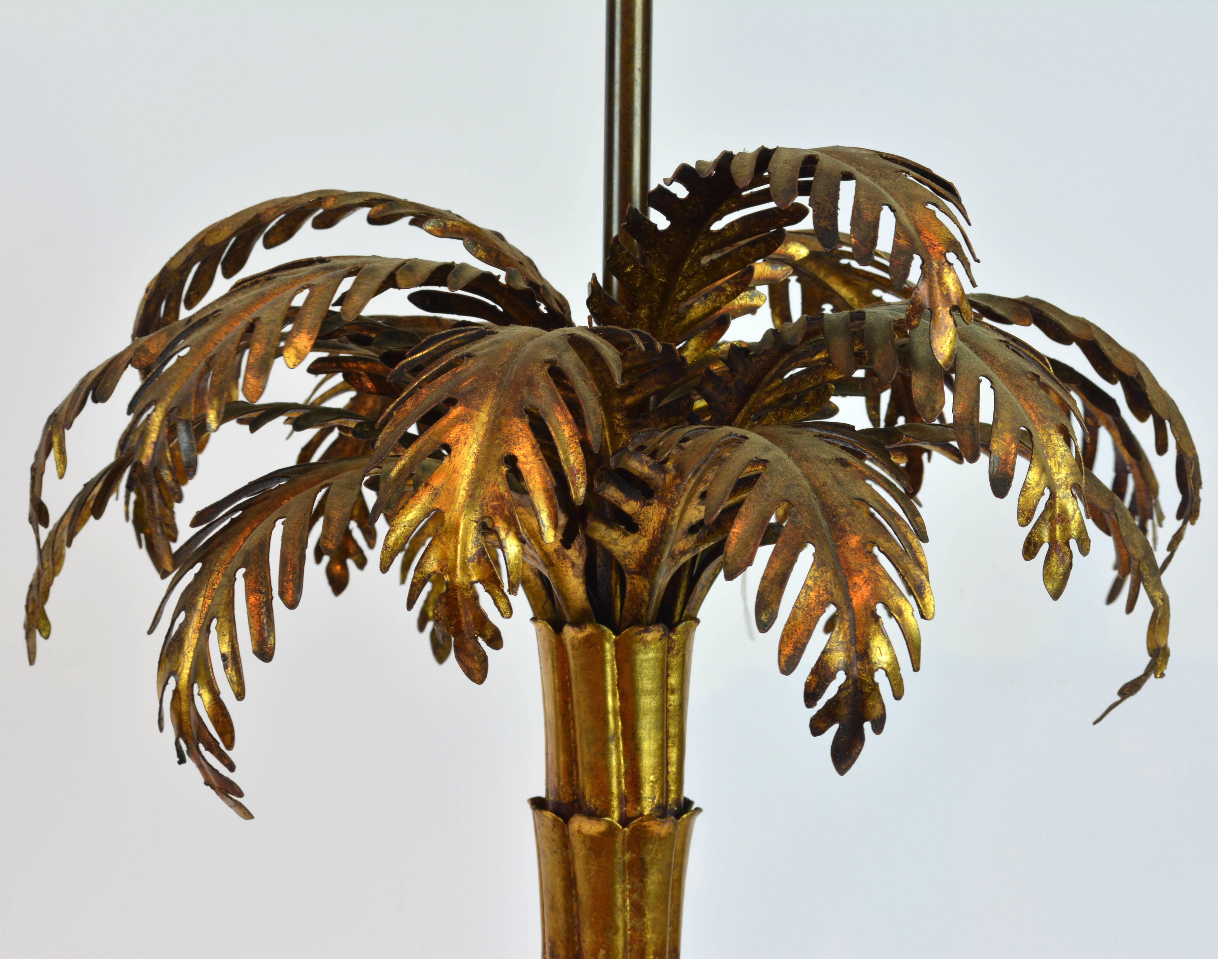 Standing 28 inches tall as shown this large sculptural lamp features a detailed modeled palm frond above a section designed stem ending in a circular base. Everything is fashioned in gilt metal with great patina.
