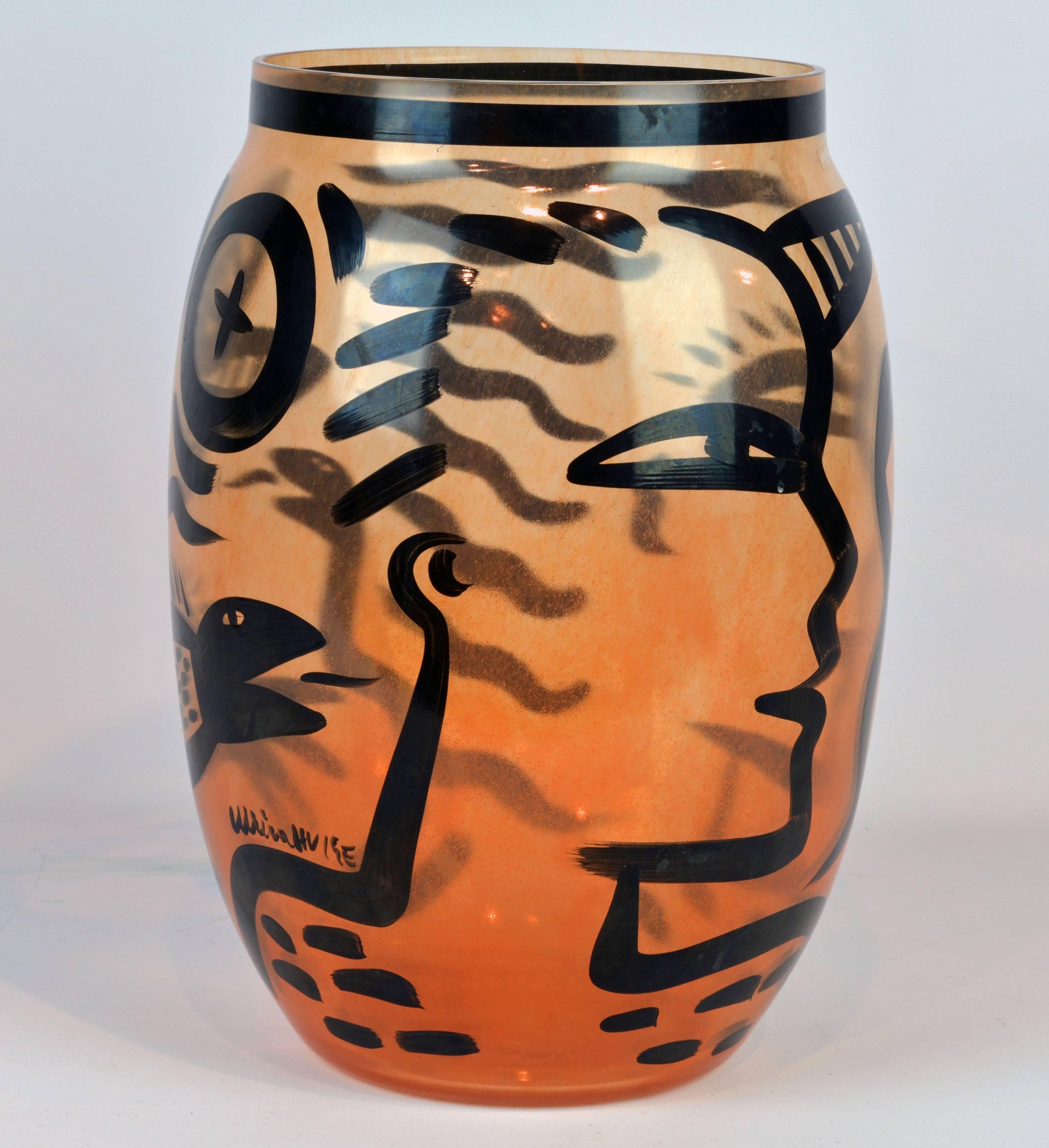 Ulrica Hydman-Vallien is known for her bold approach to figurative art and for her use of archetypal motifs in this case the Adam and Eve theme. Standing 13.5 inches tall this handblown and artist painted amber colored vase by Swedish Kosta Boda has