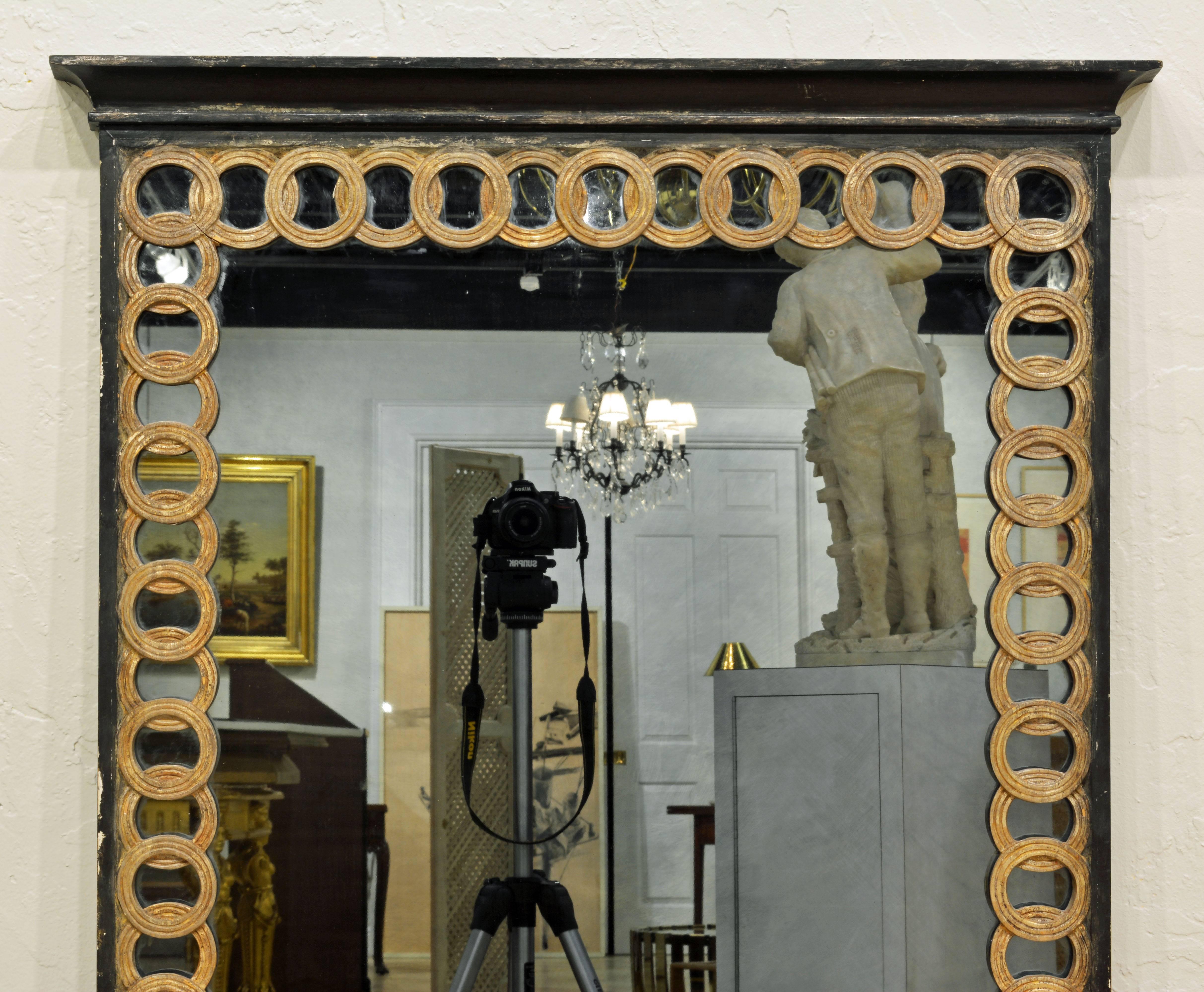 Bordered by the Palladio version of the Celtic Ring frieze this mirror features a combination of black frame and gilt rings, a motif also used in other Palladio items. Standing almost 53 inches tall, the mirror is great for many purposes.