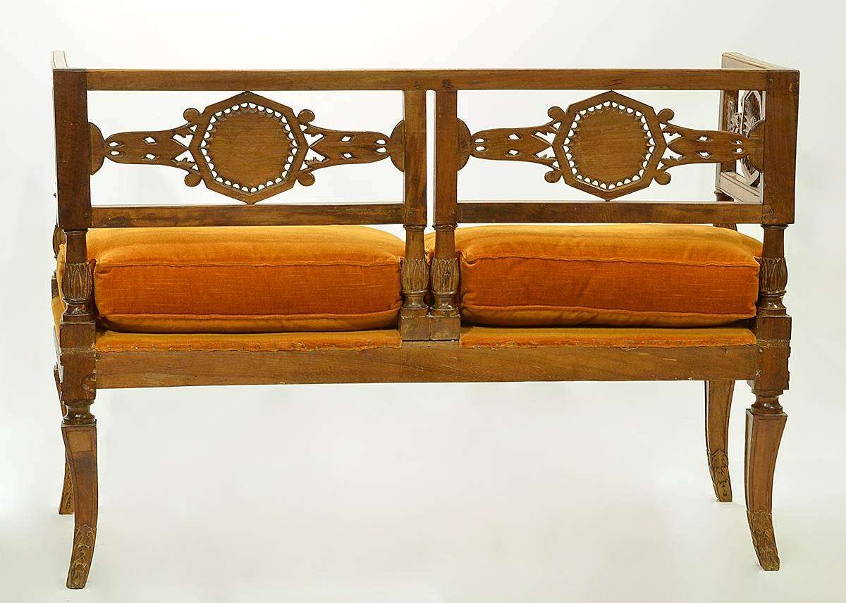 A rare Italian neoclassical settee of square angular form with wonderfully carved reticulated foliage splats centering sunbursts, resting on classical splayed sabre legs. This settee dates to the early 19th century.