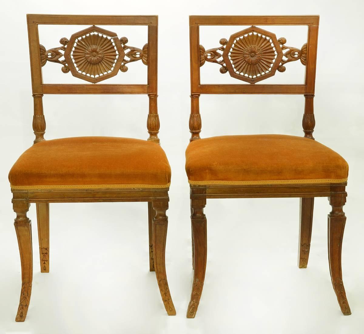 A pair of rare Italian neoclassical side chairs with wonderfully carved reticulated foliage splats centring sunbursts, resting on classical splayed sabre legs. These chairs date to the early 19th century.