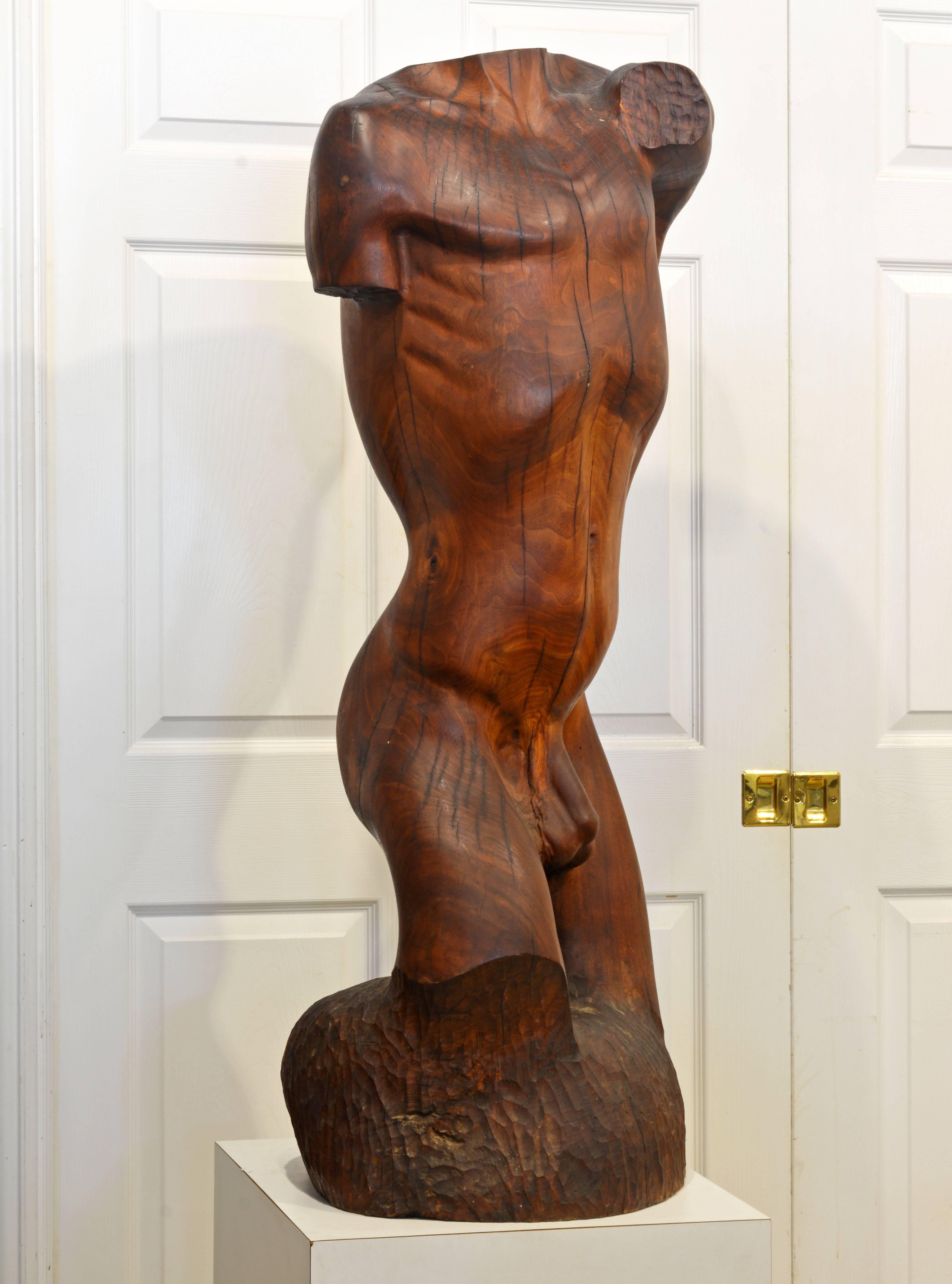 Standing 47 inches tall this statue is carved out of a hardwood tree trunk and combines naturally organic lines with the artist strong intentions. The statue offers new surprising perspectives from all sides complimented by the warm wood tones and