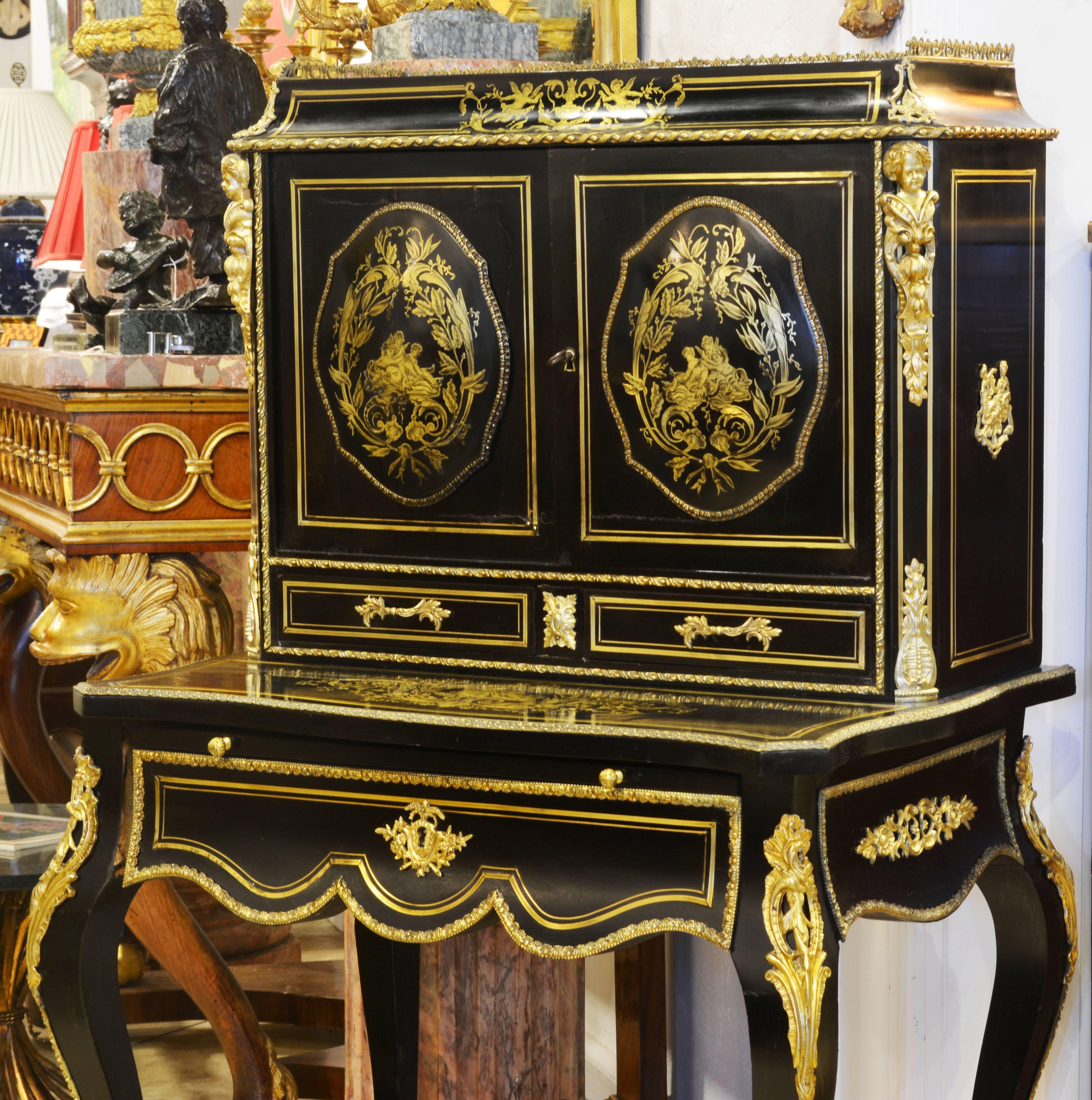 This superior desk features a gallery top above two domed paneled doors and two small drawers. The lower part offers a pull-out writing tablet above a long frieze drawer supported by elegantly curved cabriole legs ending in ormolu sabots. Over all