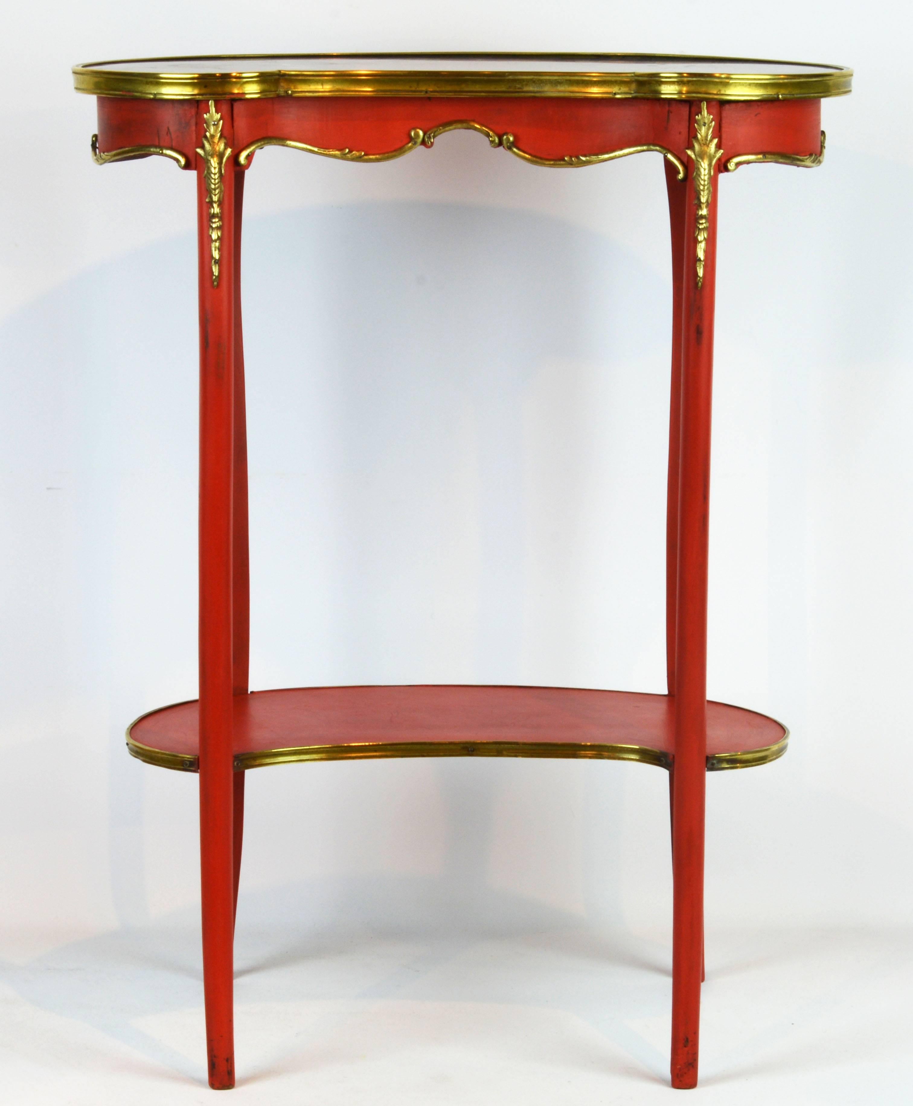 This charming late 19th century table features a kidney shaped and bronze edged marble top above a scalloped bronze-mounted frieze raised on for round slender cabriole legs joined by a lower bronze edged tier shelf.