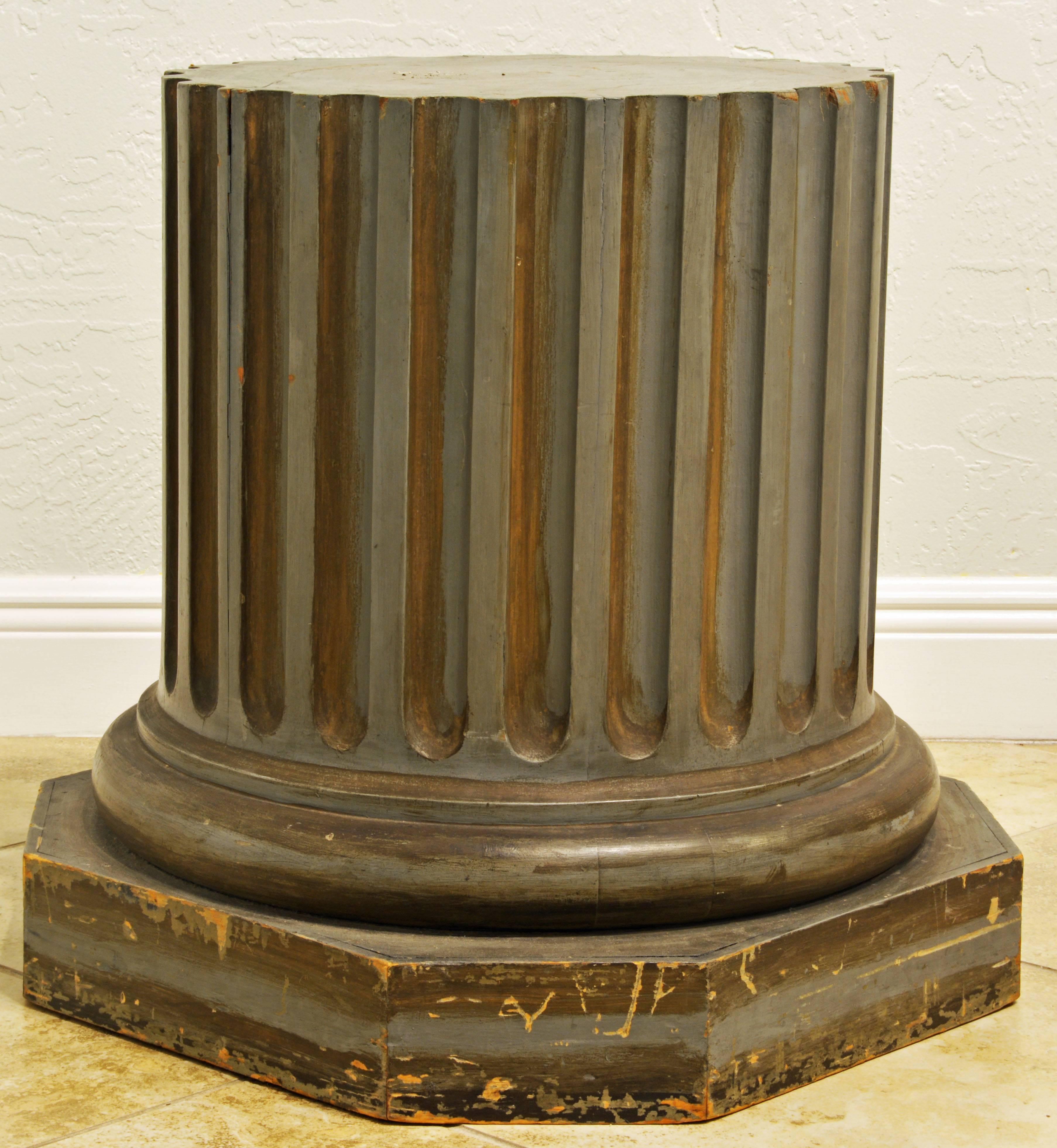 This almost Gustavian looking painted column base pedestal features a carved fluted column shaft on a circular moulded base resting on an octagonal stylobate. Very Classic and no nonsense. Great for a statue or even a glass top coffee table.