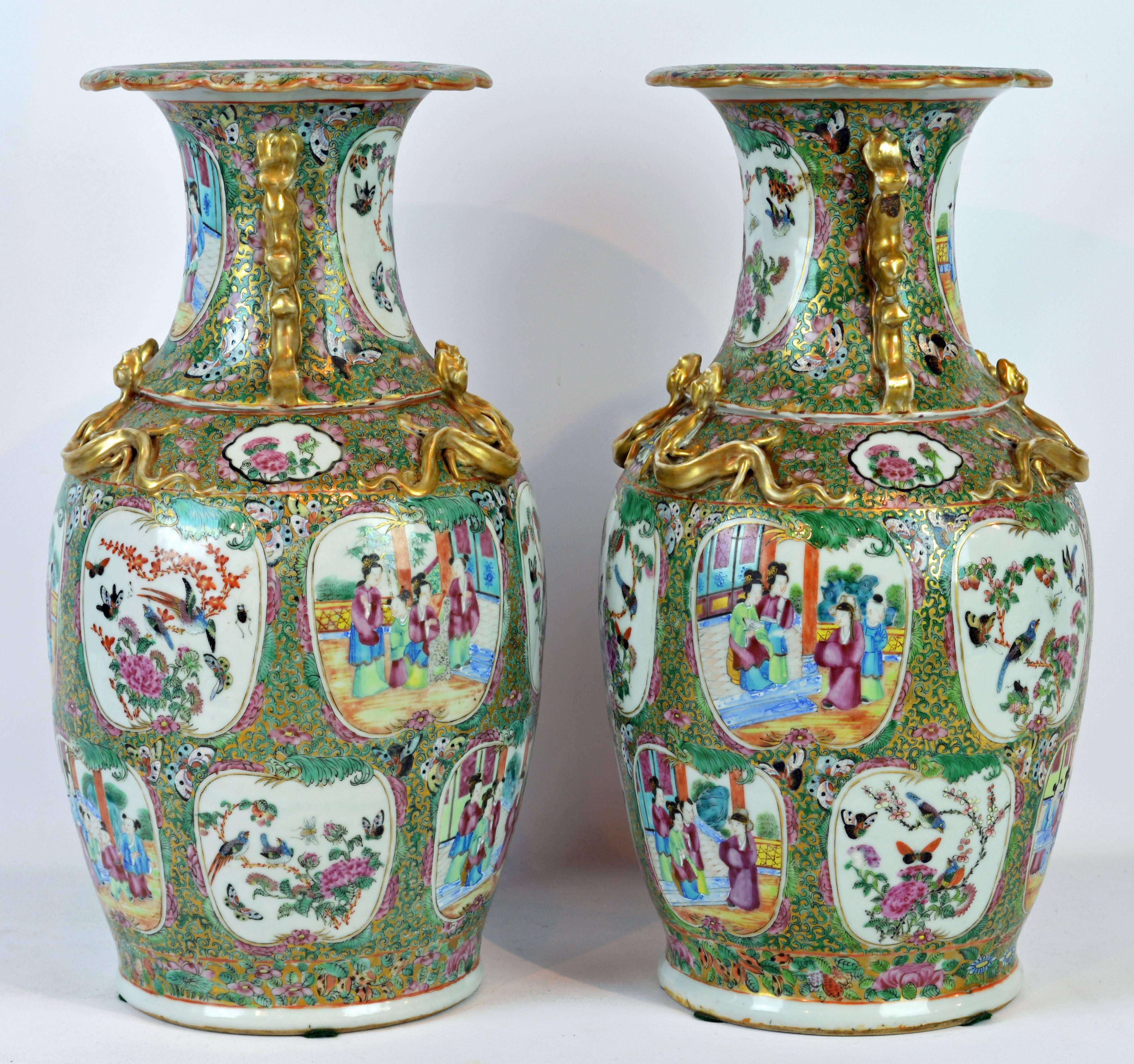 This fine 19th century pair of rose medallion vases adorned with high relief gilt lizards and animal handles feature cartouches depicting family life, flowers and birds on a green and pink enameled ground.