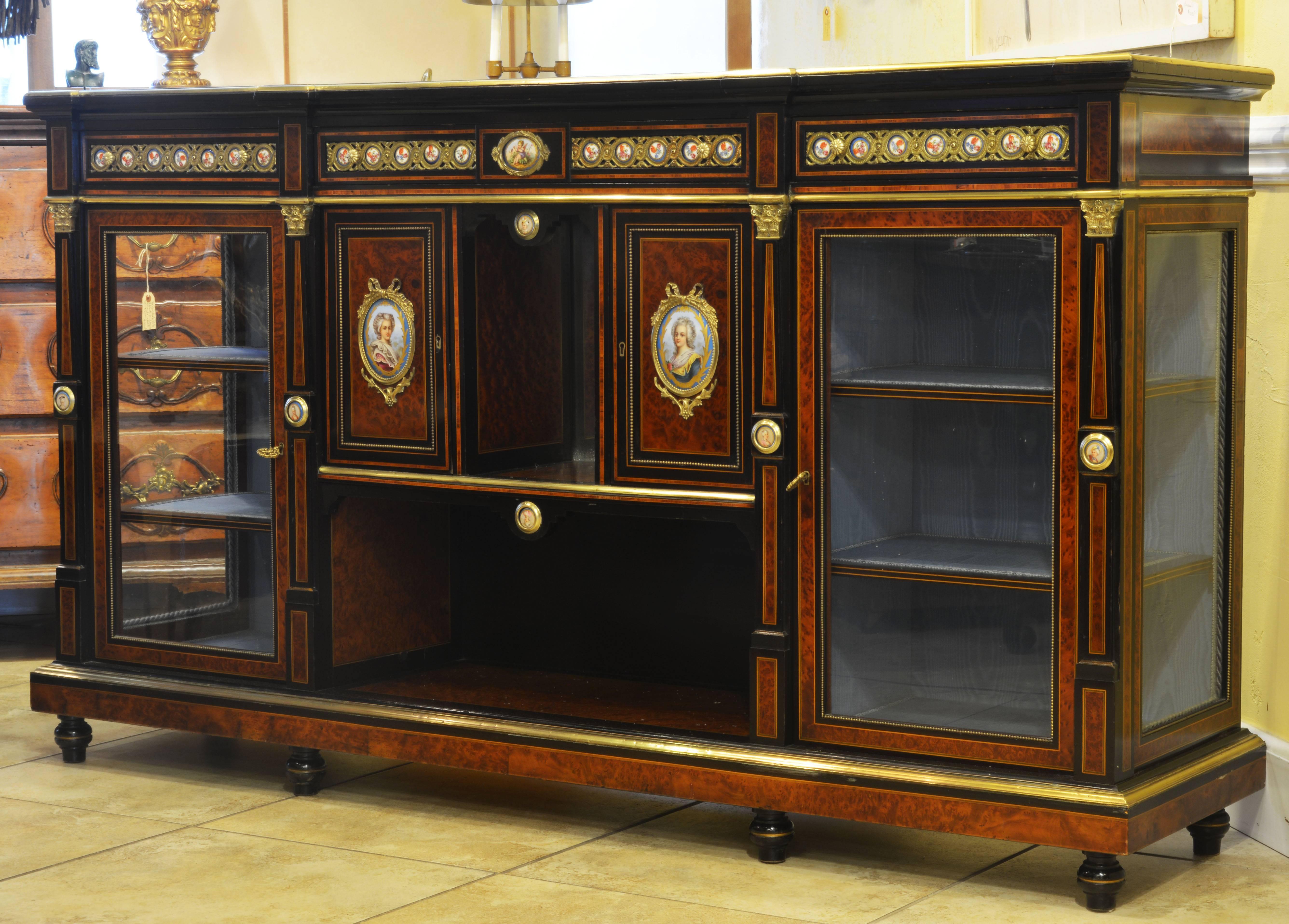 This credenza is among the very best of its kind. All surfaces consist of ebonized borders, kingwood string inlay and central panels of Circassian burl walnut veneer. 33 Sevres porcelain plaques with portraits, cherubs and flowers adorn the special