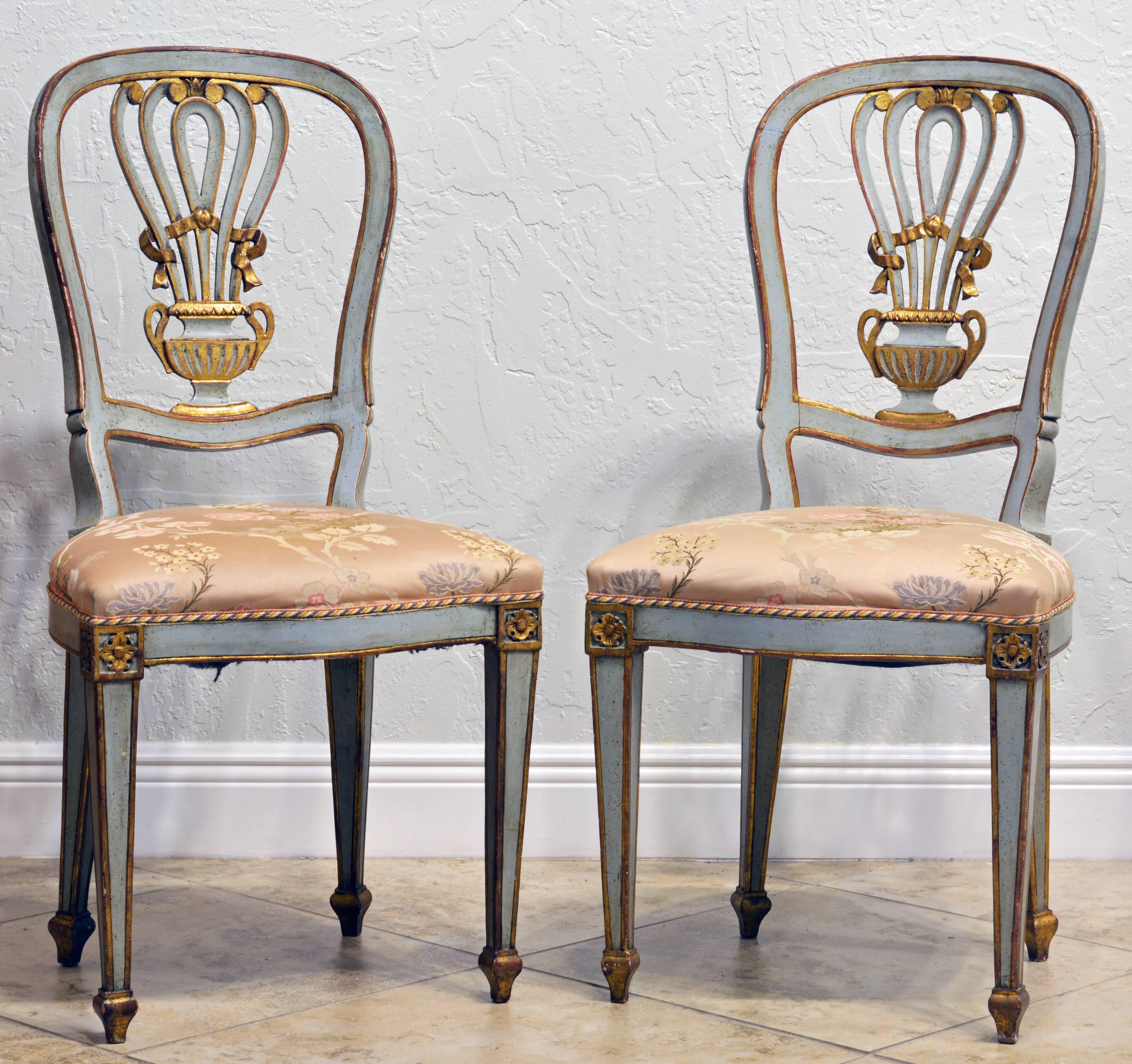 The combination of the grey paint and decorative gilt accents is very pleasing. The curved back frame centers a charming gilt urn and ribbon splat. The seats are upholstered and covered with peach colored apple blossom brocade in excellent condition.