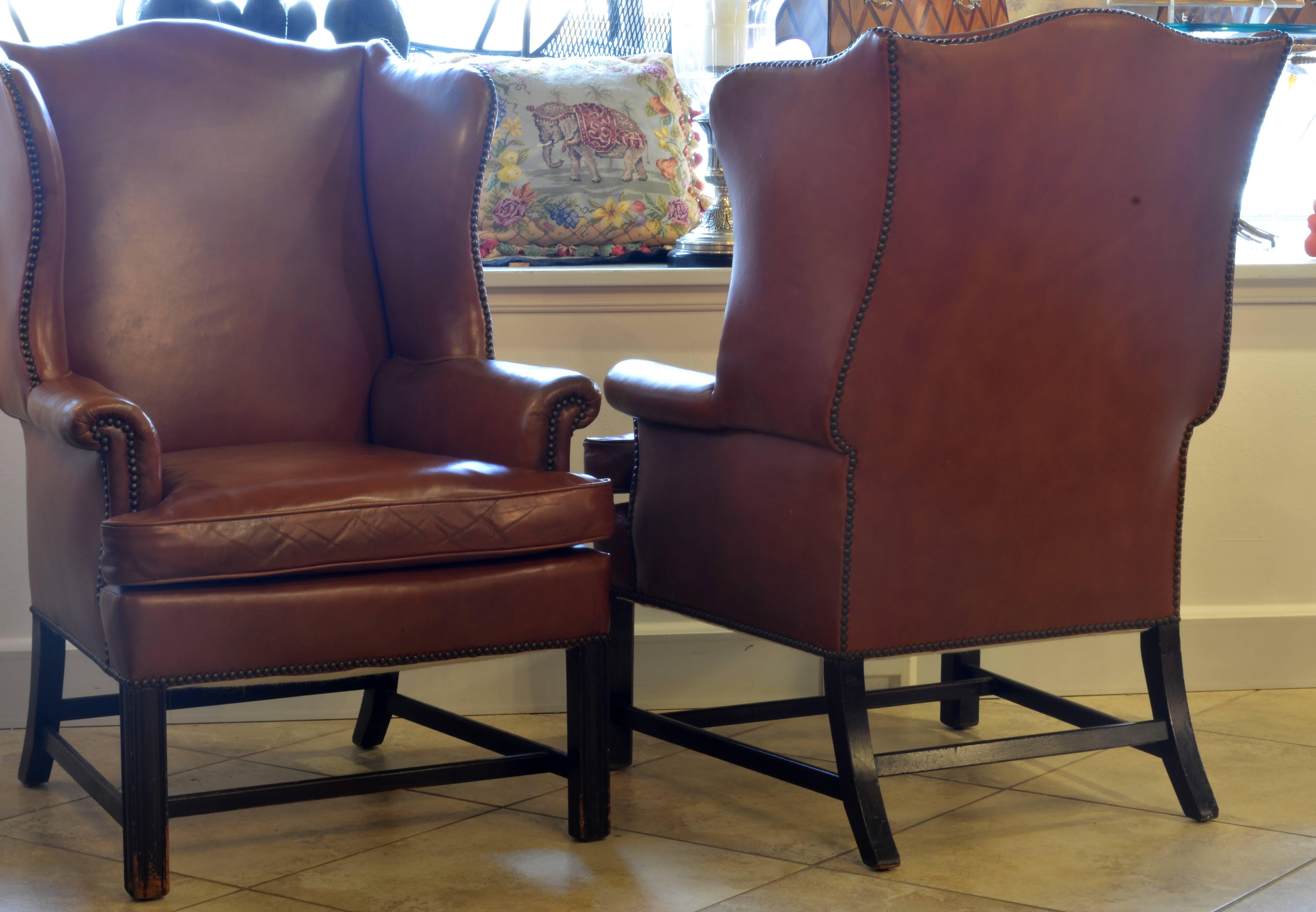A pair of exquisite vintage Georgian style wing back leather armchairs. An iconic chair and ours are in great condition including the leather which has a nice color and texture.
