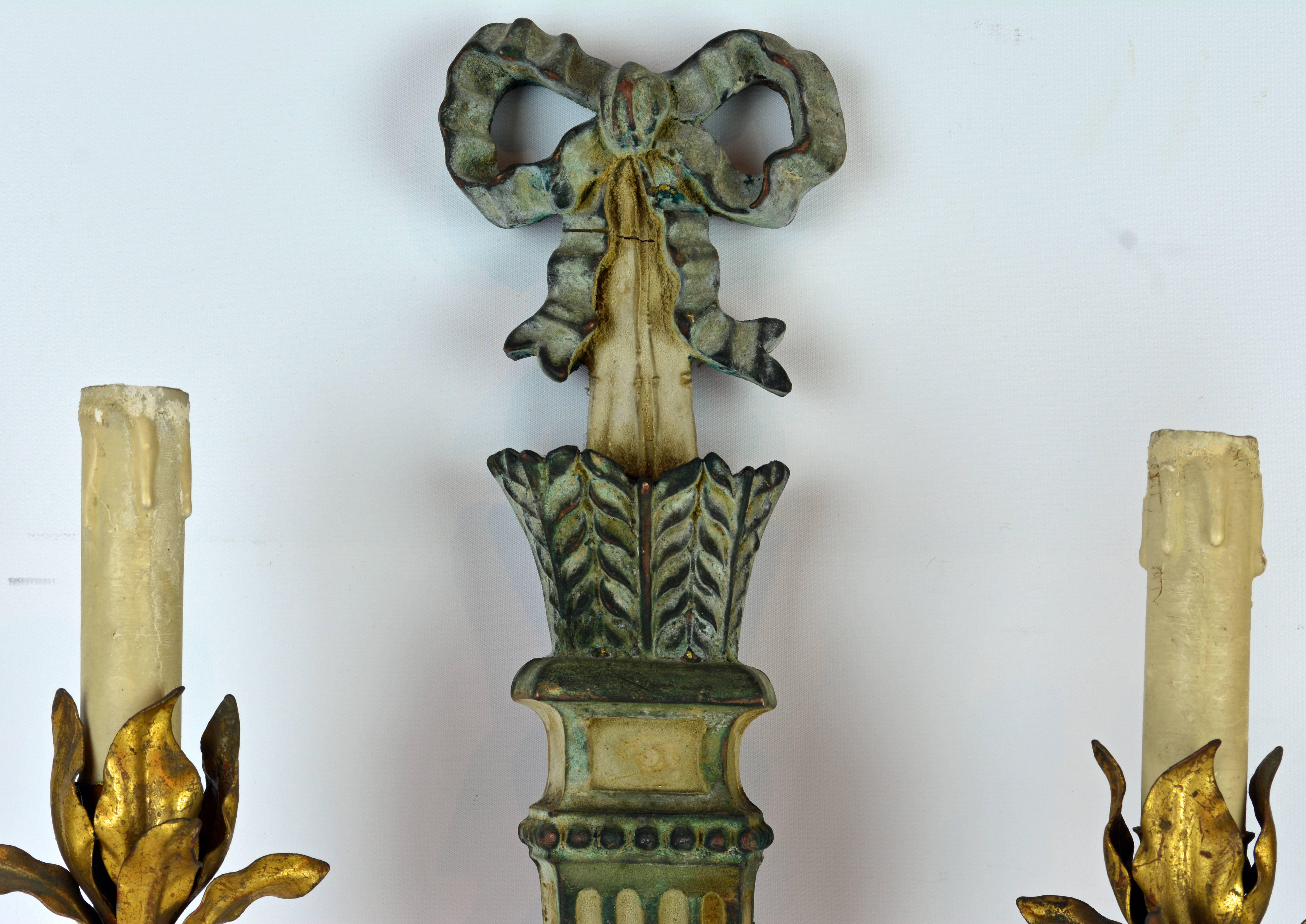 The classical fluted and painted quiver themed stem surmounted by a Louis XVI style ribbon supports two gilt metal leafwork light arms ending in electrified faux candles.