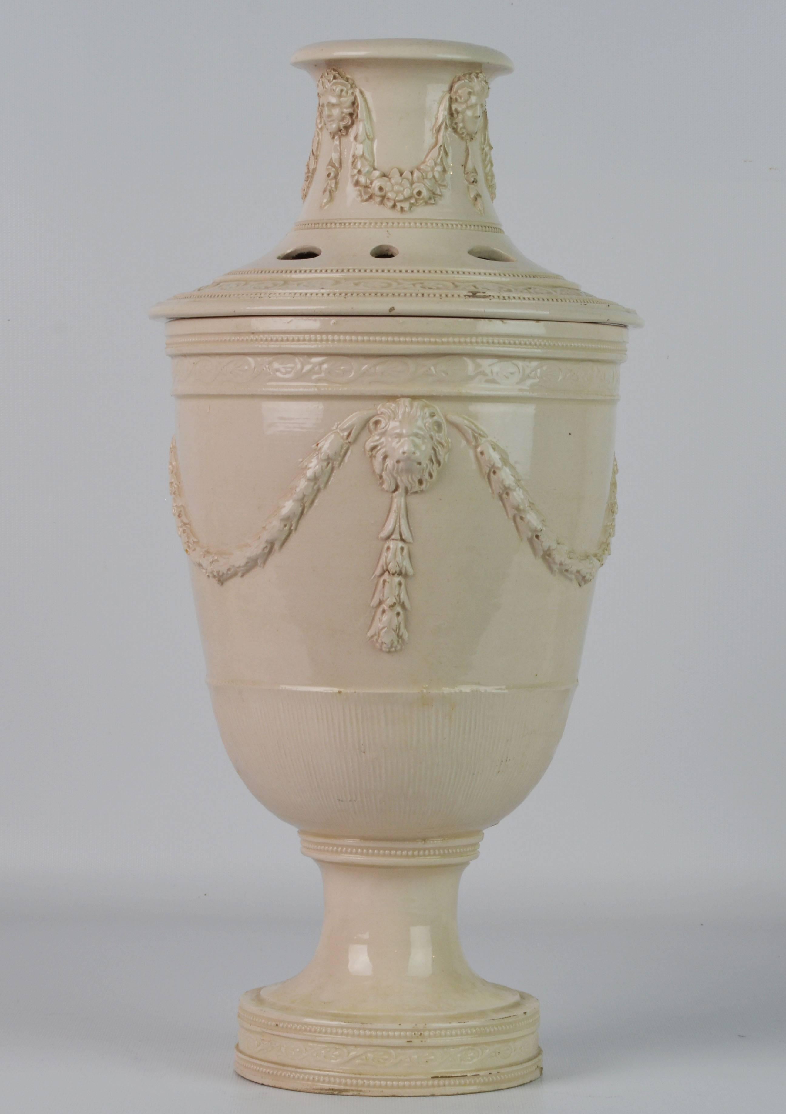 Standing 16 inches tall this rare piece of pottery in the Georgian style (reminiscent of Louis XVI style) could likely be Leeds creamware and consists of the reticulated cover surmounted by an open neck with garlands and masks in relief above the