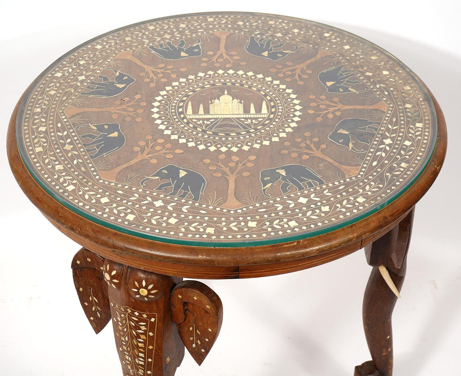 Early 20th Ct. Anglo Indian Carved Wood and Inlaid Round Elephant Table. Fitted glass top. Inlaid top with Elephants and tree design.