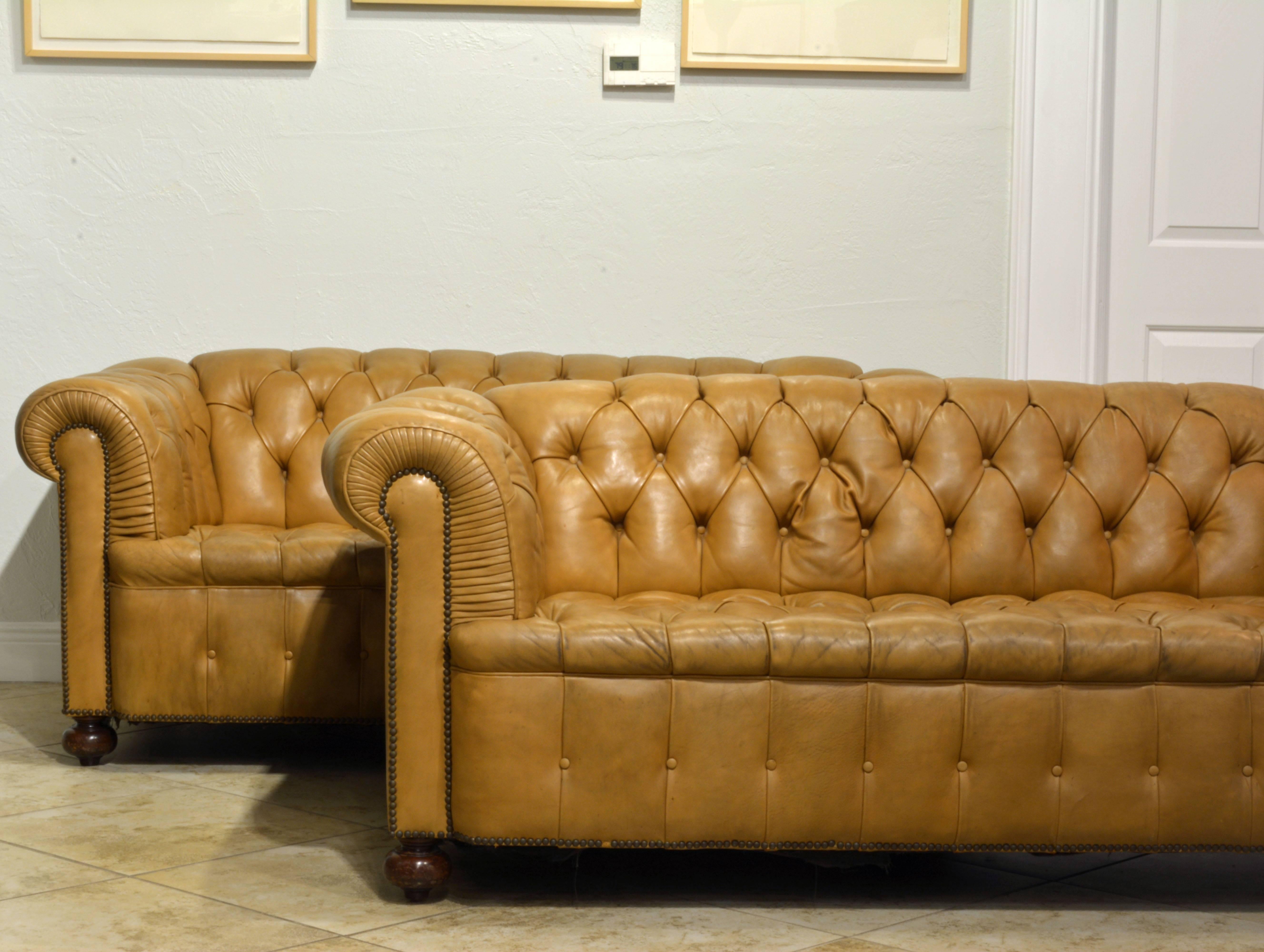 Beautifully detailed this identical pair of Classic Chesterfield sofas resting on pointed bun feet evoke notions of the English country manor and the unusual light color will compliment even a more modern interior.