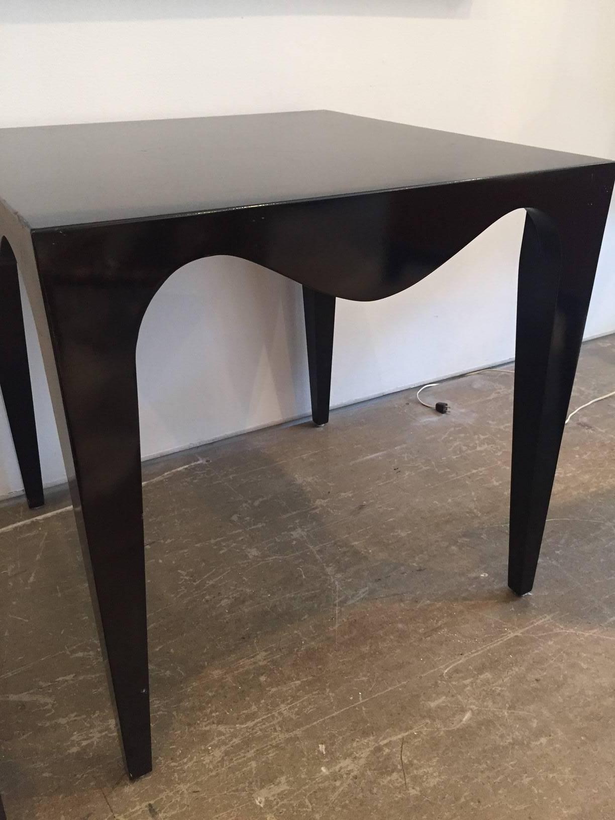 Black lacquer gaming table with curved apron detail.