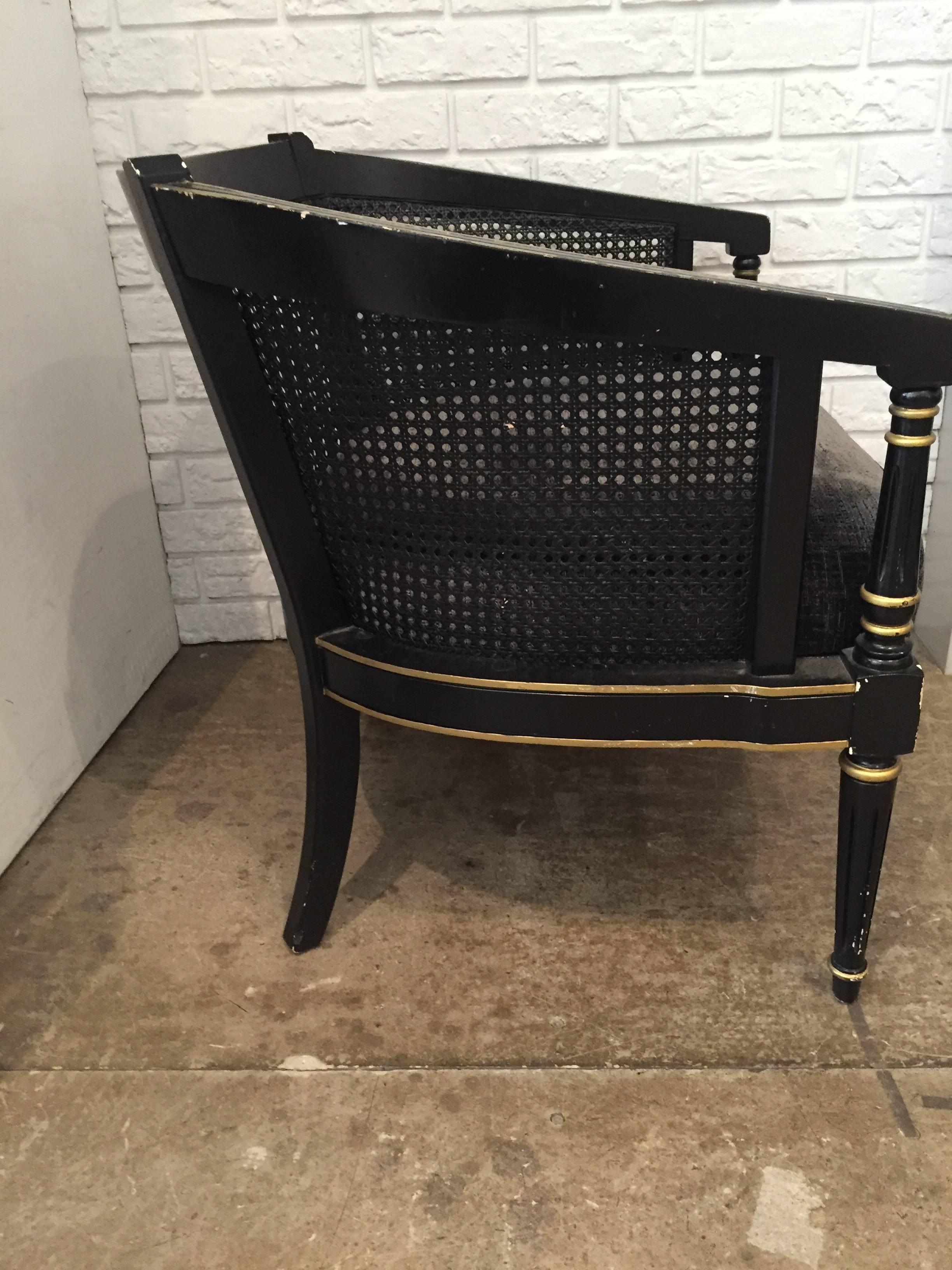 Pair of Empire-style barrel back chairs. Black base with gold leaf detail and cane back. Newly upholstered cushion in a textured charcoal velvet.