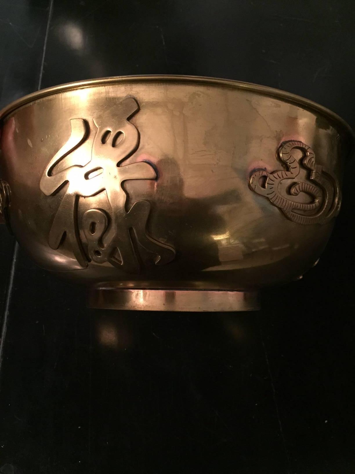 Asian brass bowl with decorative applications.