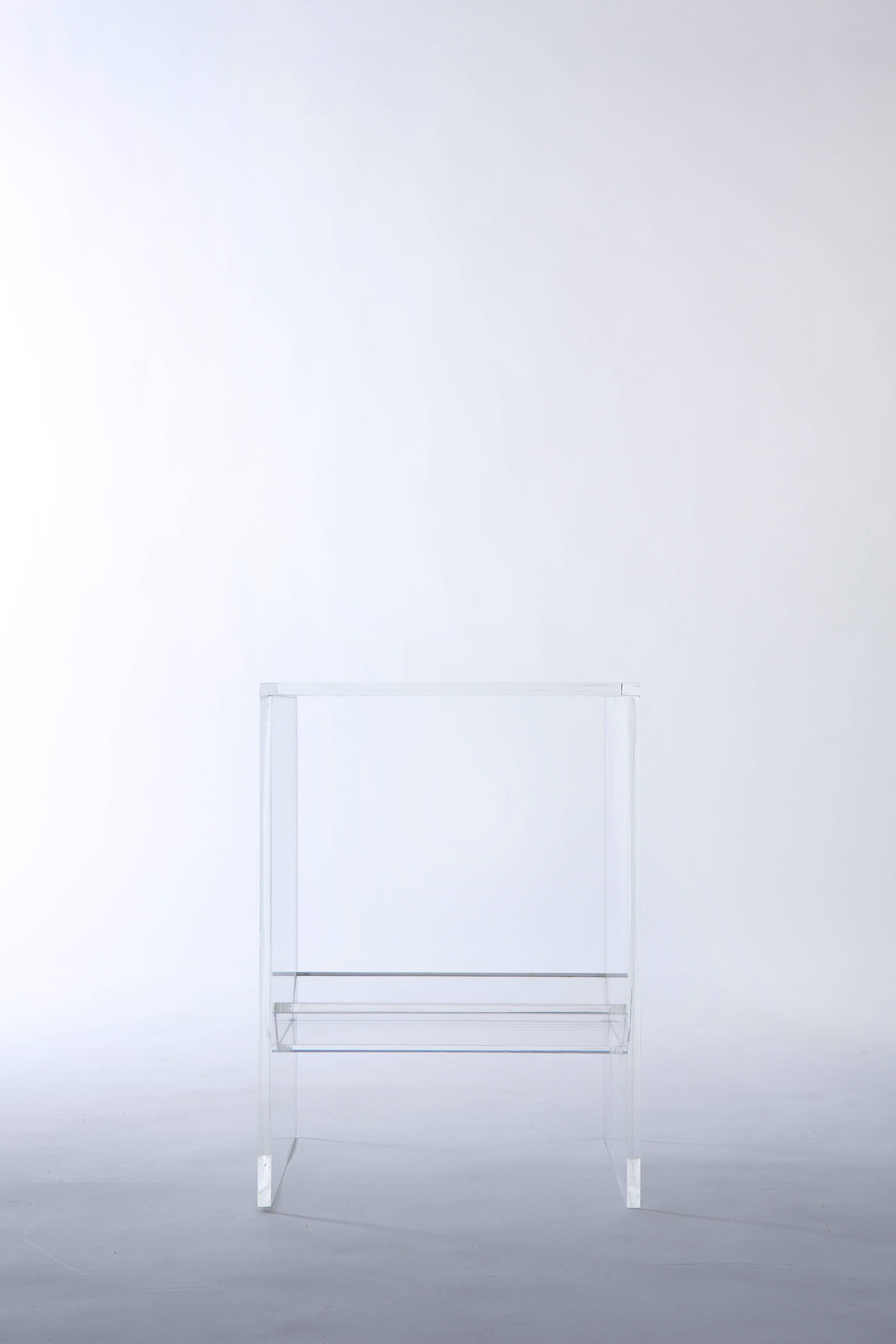 Like the other members of our 'Bond Series', this completely transparent acrylic side/end table is defined by the trough nestled underneath its surface. The trough enables you to curate your own sub-seat terrarium, or to display your own accents,