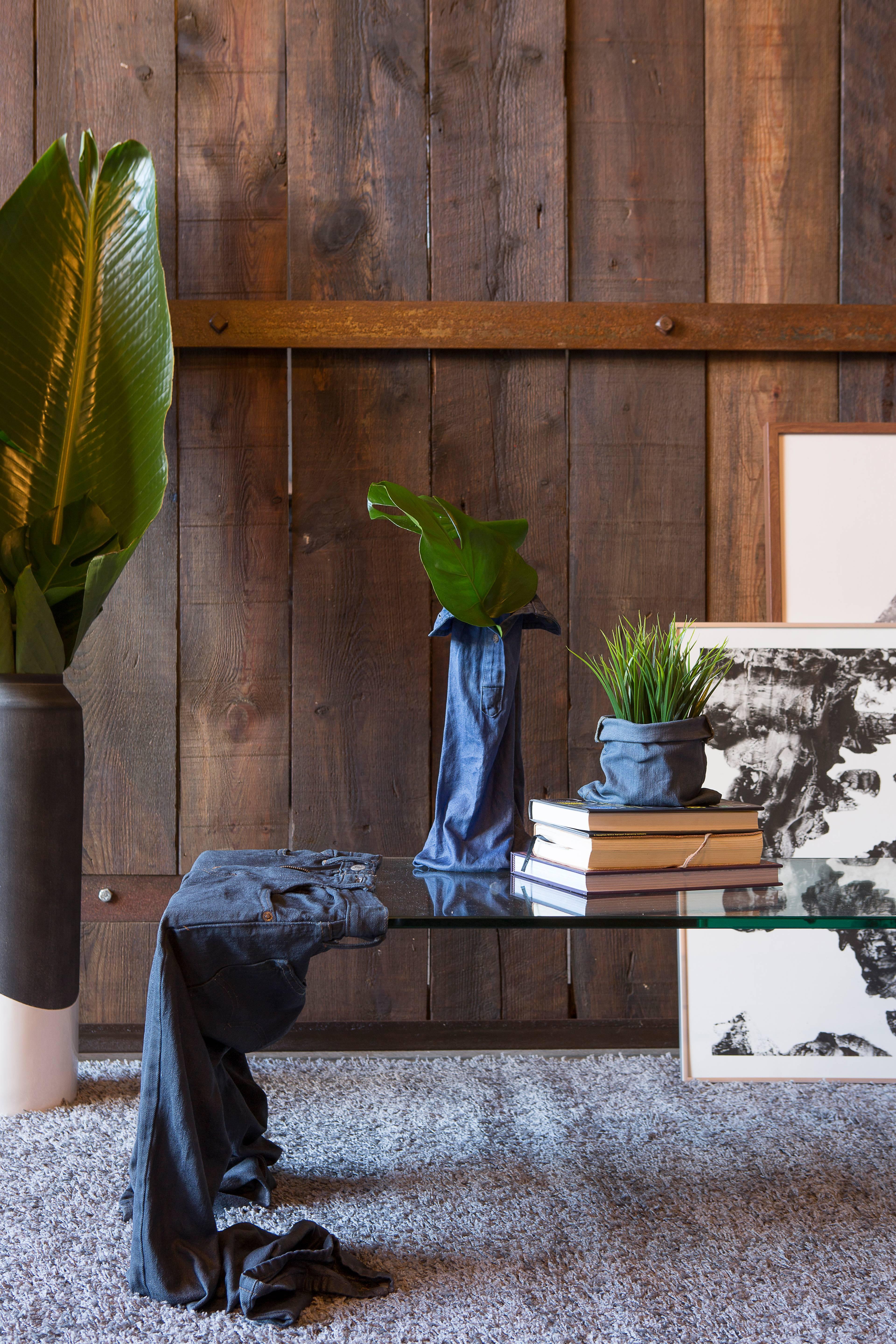 This table serves as a statement piece, using recycled denim jeans to support a sheet of tempered glass. The denim jeans are hardened using resin, turning them into sturdy supports for the glass surface.  

Base Materials: Cotton and EcoPoxy