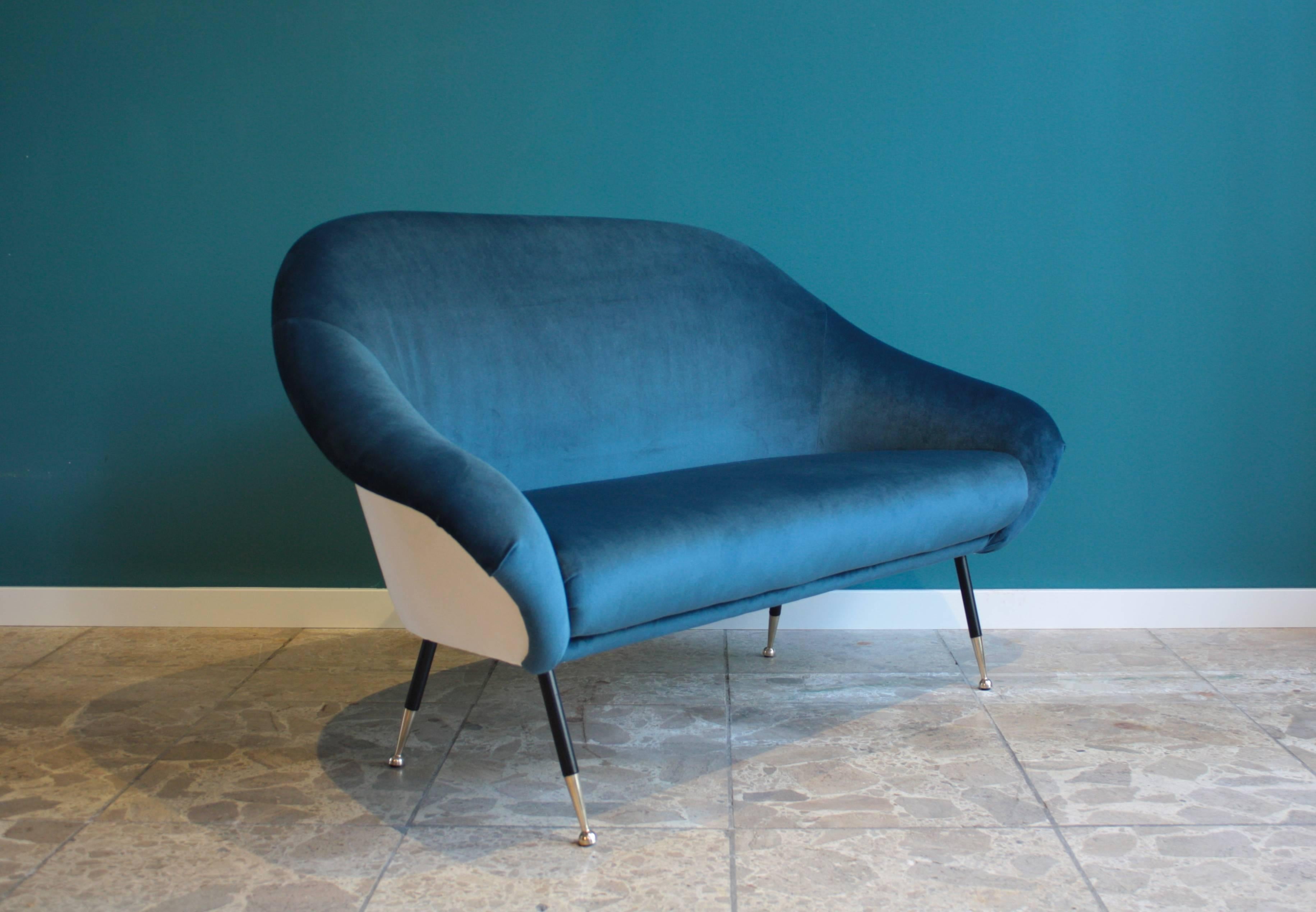 This organically shaped two-seat sofa was made in Italy in the 1950s. It features bronze legs and has been reupholstered with a dark blue and white velvet-like fabric. 