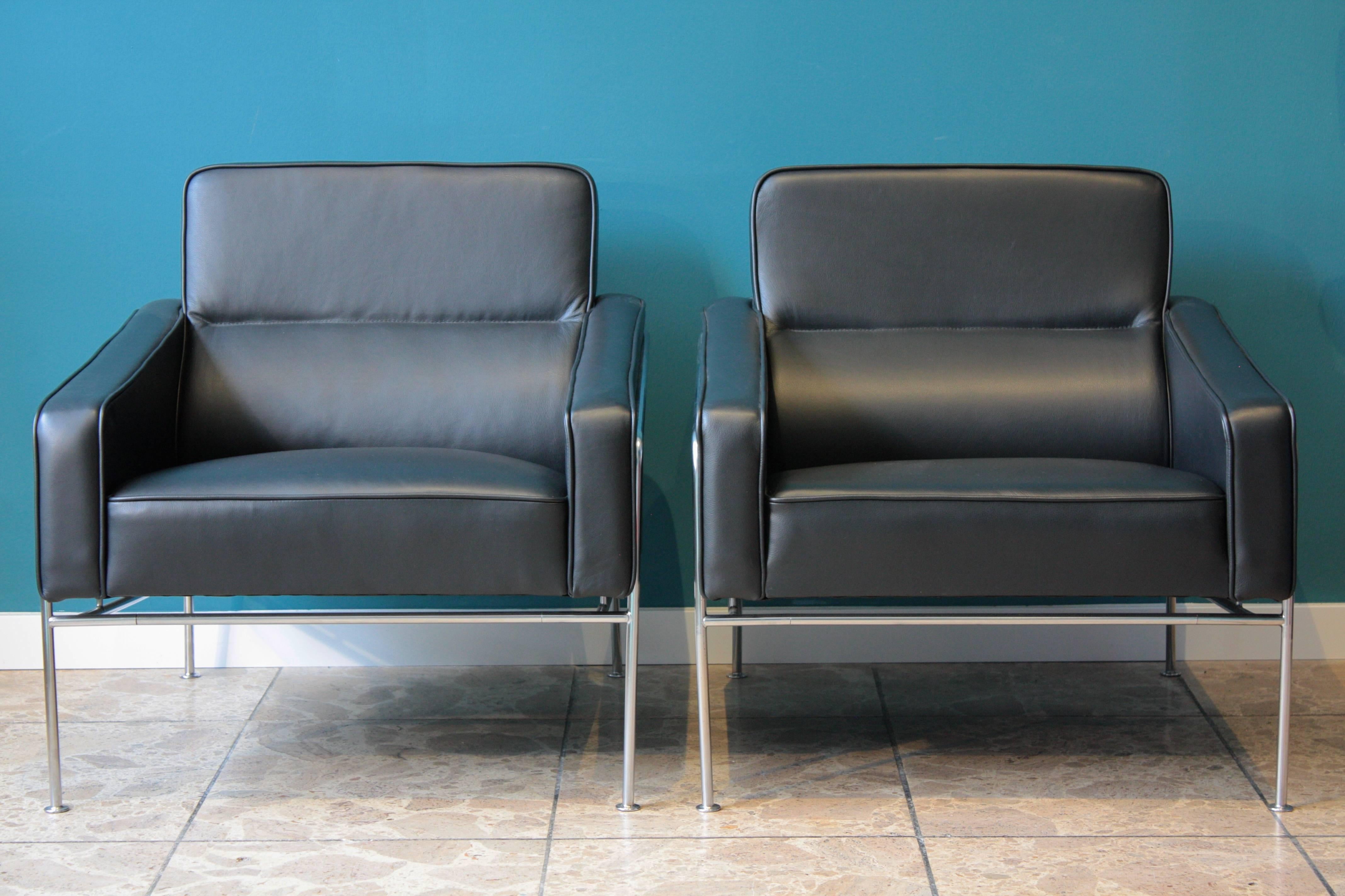 Two Airport chairs, model 3300, designed by Arne Jacobsen and produced by Fritz Hansen, professionally reupholstered in black semi-aniline leather, chromed steel frame. The series was produced for the SAS Terminal at the Royal Hotel in Copenhagen,