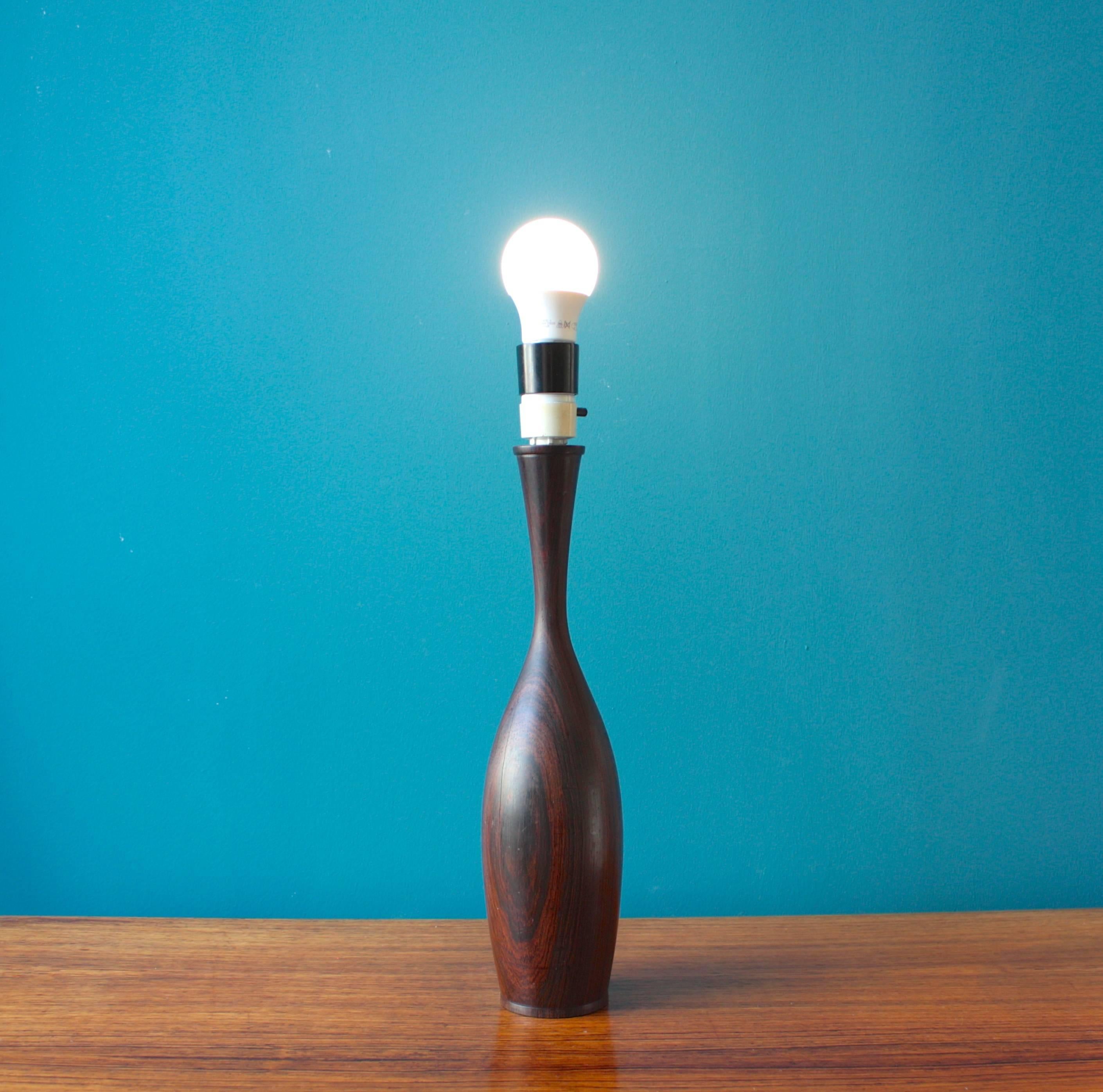 This table lamp was designed and produced in Denmark in the 1960s. The base is made from rosewood with a fabric lamp. It is in very good vintage condition.