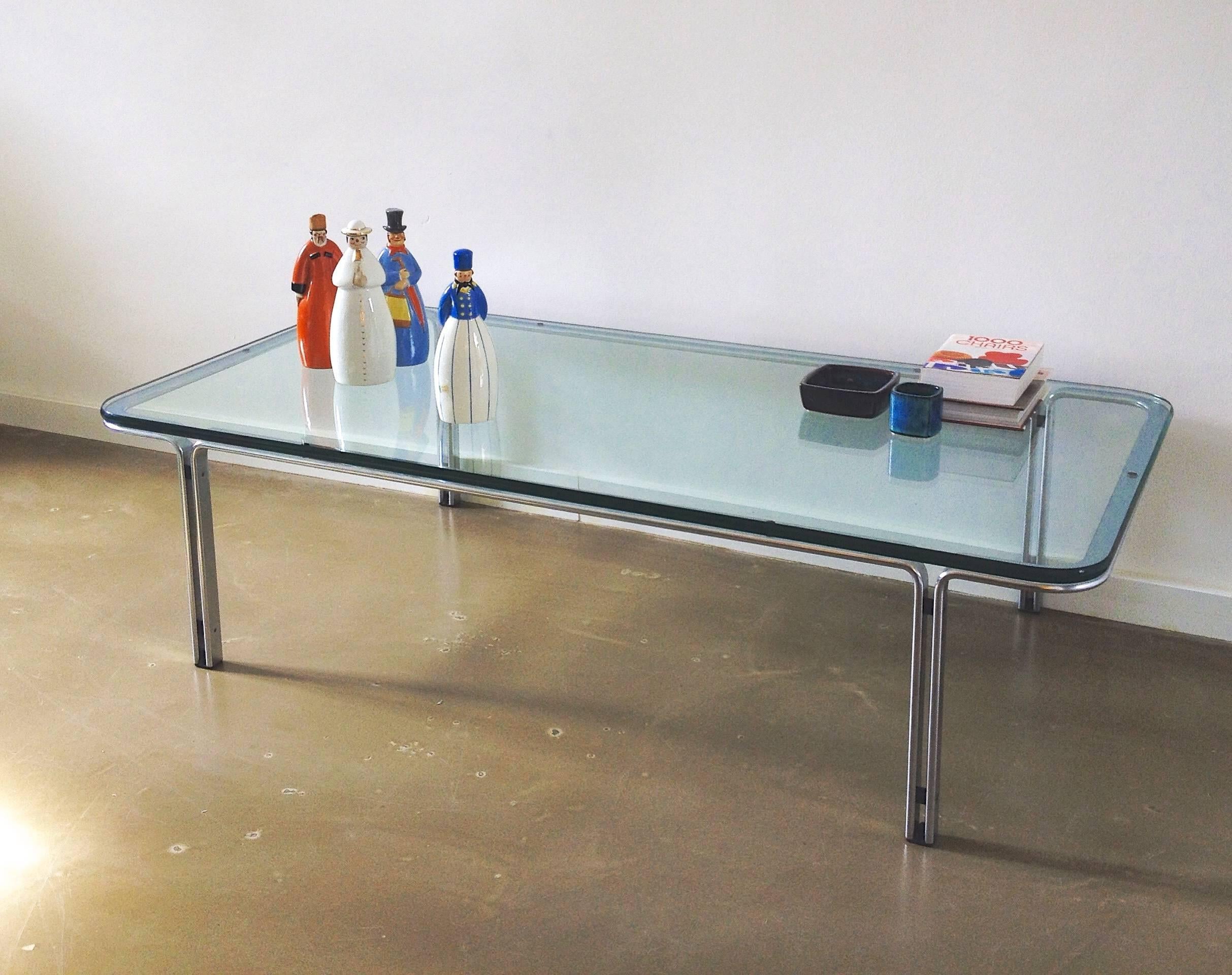 This T112 coffee table was designed during the 1970s by Horst Bruning and manufactured by Kill International in Germany. It features a structure made from chrome-plated steel as well as a thick glass tabletop.